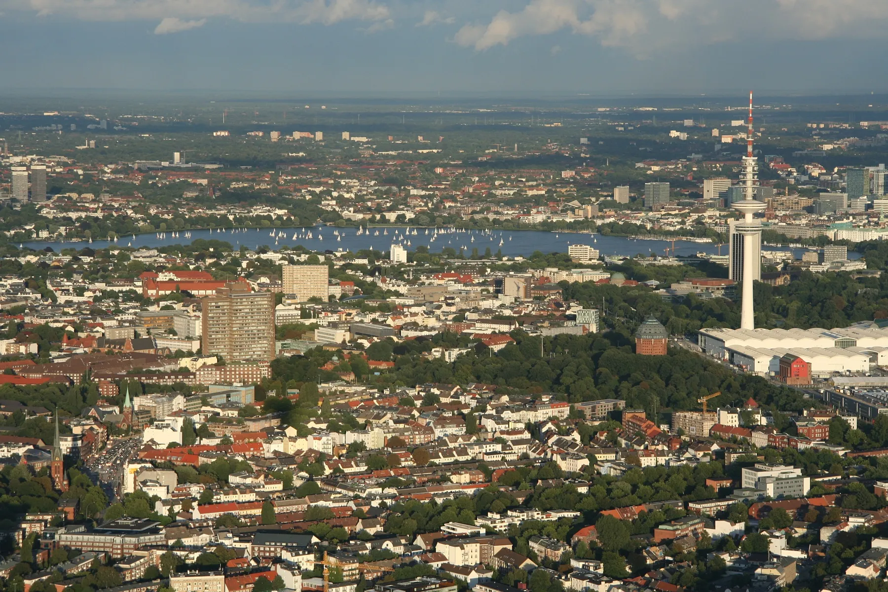 Photo showing: Im Vordergrund: Schanzenviertel, Messehallen (rechts im Bild), Heinrich-Hertz-Turm, in der Bildmitte: Rotherbaum, Außenalster