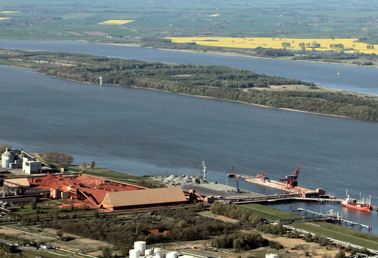 Photo showing: Luftaufnahme der Elbinsel Pagensand und Seehafen Stade, an dem das schwimmende LNG-Terminal im Jahr 2023 entstehen soll. Davor im Bereich der Buschfläche soll bis 2026 das stationäre LNG-Terminal errichtet werden