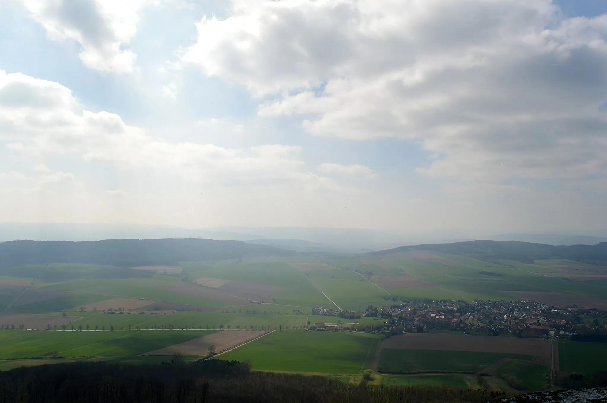 Photo showing: Blick vom Ithturm (im Naturschutzgebiet „Ith“) nach Westen über Bisperode (rechts) zu den Bergrücken Hasselburg (links) und Schecken (rechts) im Landkreis Hameln-Pyrmont; abgebildeter Bereich im Naturpark Weserbergland