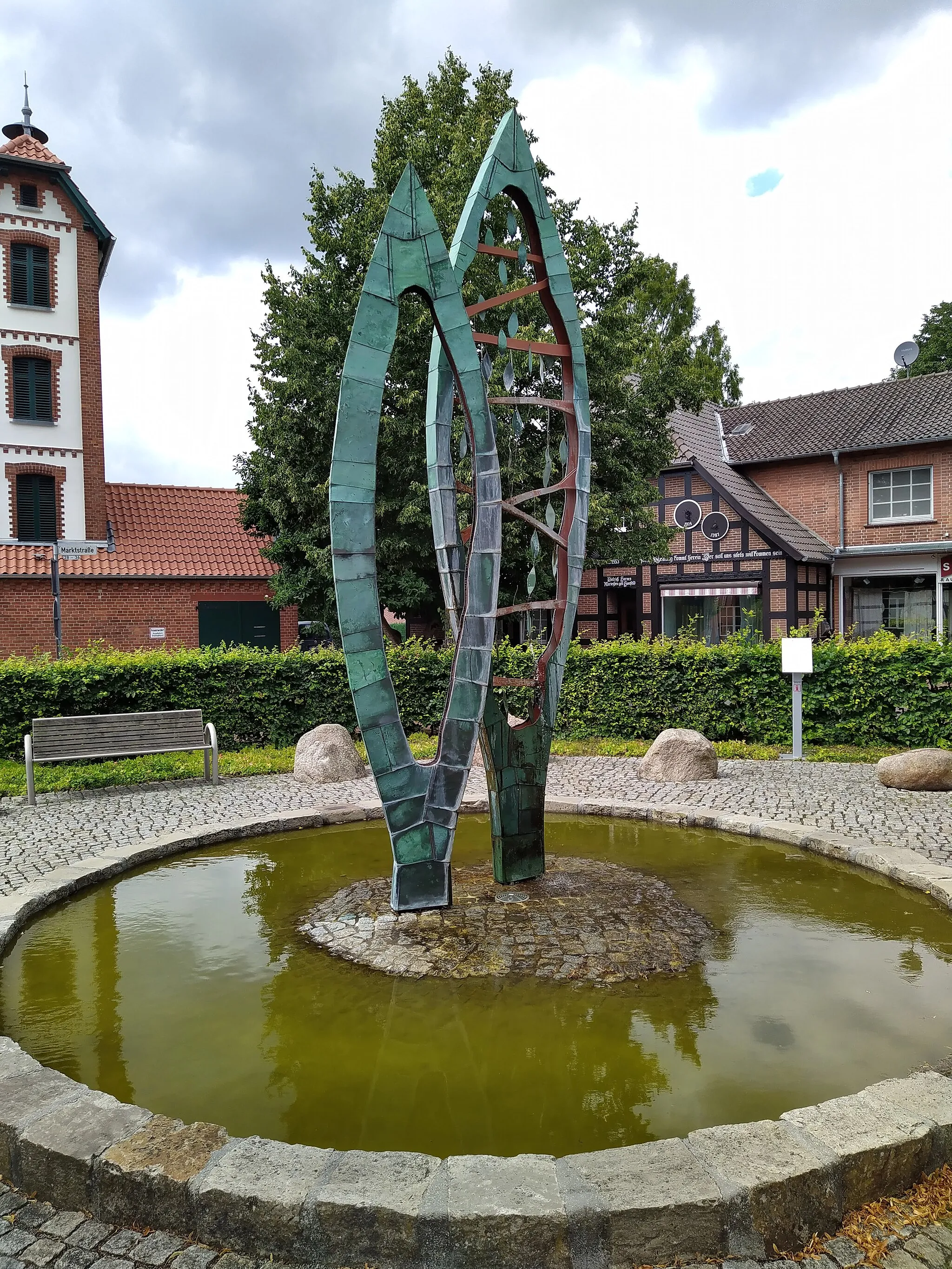 Photo showing: Brunnenskulptur "Statio" von Pablo Hirndorf vor der Kirche in Bücken