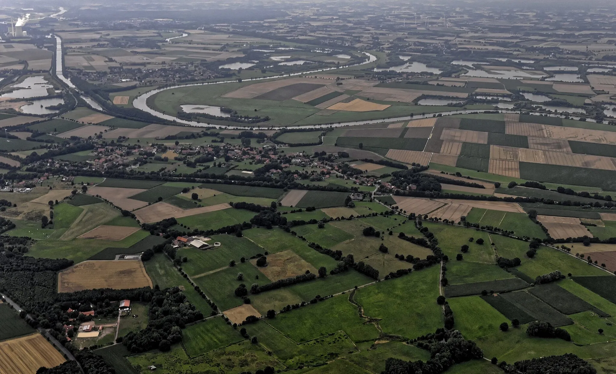 Photo showing: Bilder vom Flug Nordholz-Hammelburg 2015: Vorn Döhren an der Weser. In der Weserschleife das Vogelschutzgebiet Weseraue mit der Seenlandschaft zahlreicher ehemeligen Kiesgruben. Links oben, links der Weser, Windheim und die Windheimer Marsch. Am linken Bildrand der Schleusenkanal Lahde, und ganz oben links das Kohlekraftwerk Heyden.