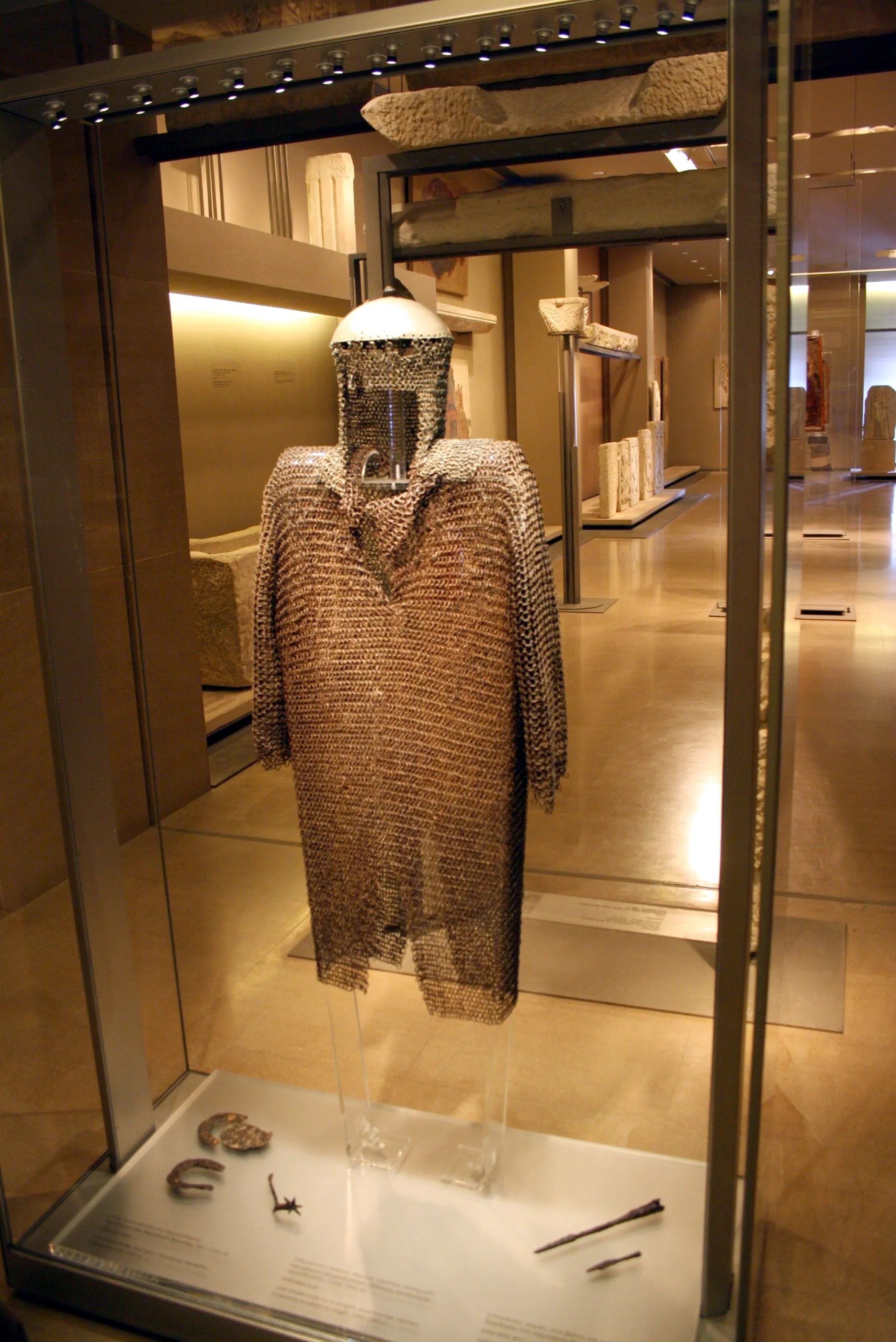 Photo showing: Iron chain mail for a Byzantine knight and bronze helmet, probably eastern origin. 13th - 15th c. Byzantine and Christian Museum in Athens. Picture by Giovanni Dall'Orto, November 12, 2009.