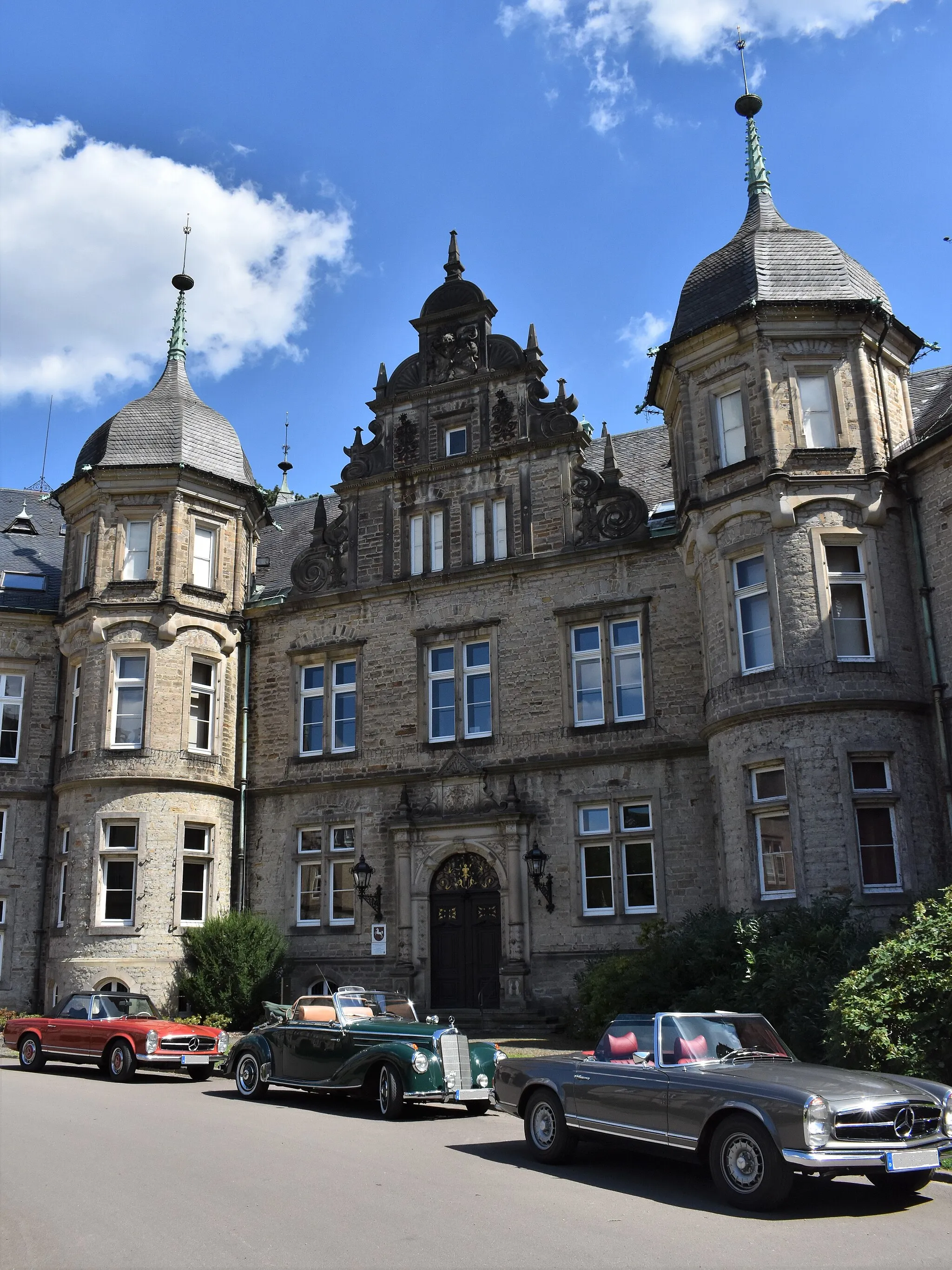 Photo showing: South-western side wing of Bückeburg Castle, which houses the Bückeburg Department of the Lower Saxony State Archives; in the foreground three vintage cars.