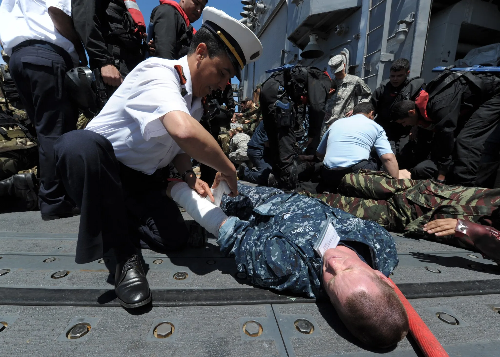Photo showing: SOUDA BAY, Crete (May 18, 2012) Petty Officer Kamel Yesli, and Algerian sailor, applies a bandage to the arm of Boatswain's Mate 3rd Class James Bare during a mass casualty drill held aboard the guided-missile frigate USS Simpson (FFG 56) during Phoenix Express 2012 (PE12). PE12 is a maritime exercise designed to improve cooperation among participating nations in order to increase maritime safety and security in the Mediterranean Sea. (U.S. Navy photo by Mass Communication Specialist 1st Class Brian A. Goyak/Released) 120518-N-QD416-149