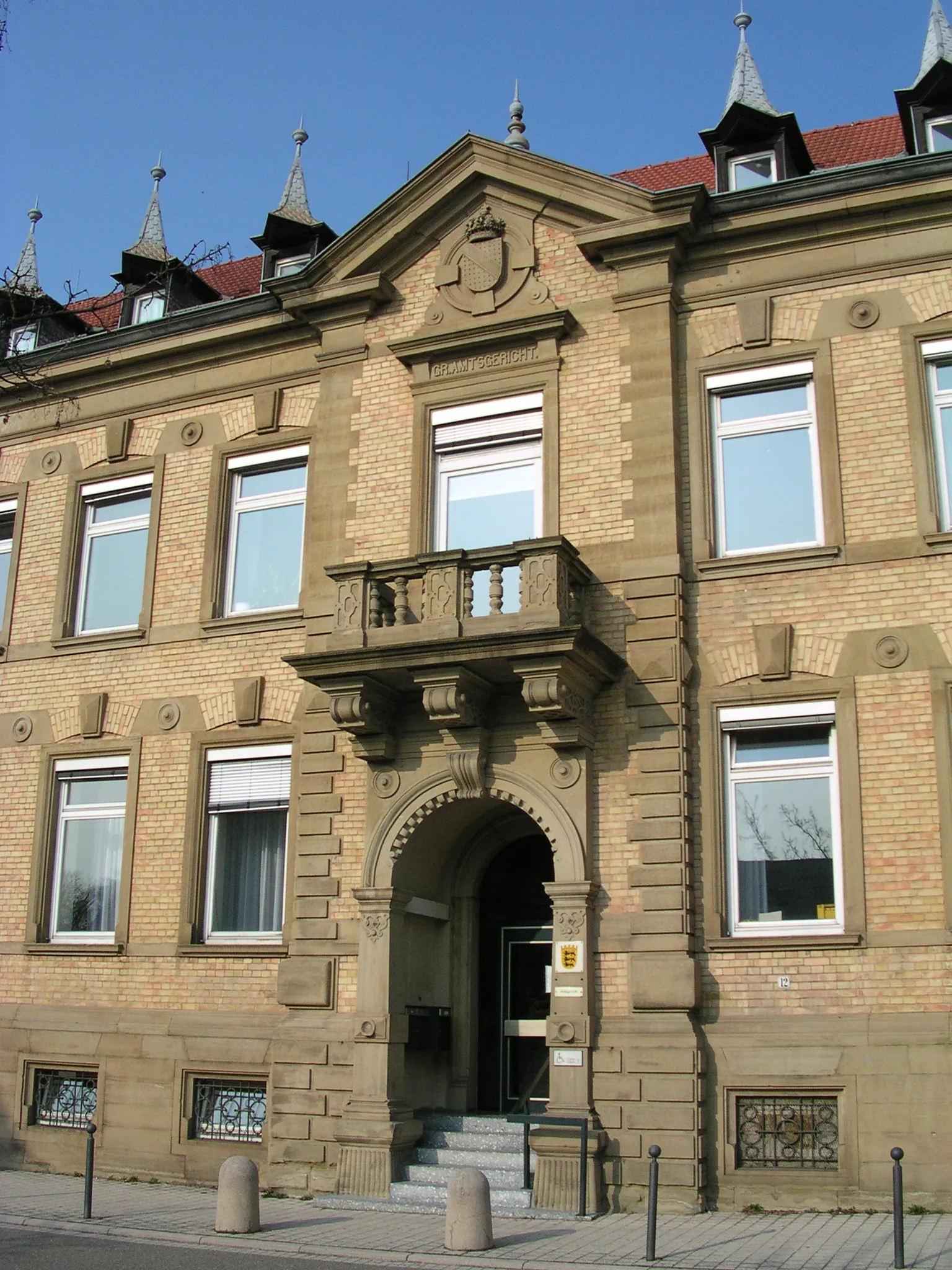 Photo showing: Von 1894 bis 1996 baute man an der Werderstraße das ehemals großherzoglich-badische Amtsgericht. Architekt war Julius Koch, Vorstand der Bezirksbauinspektion Heidelberg. Fassade mit Steinmetzarbeiten und schmuckreichen Giebeln, Landeswappen mit Krone.