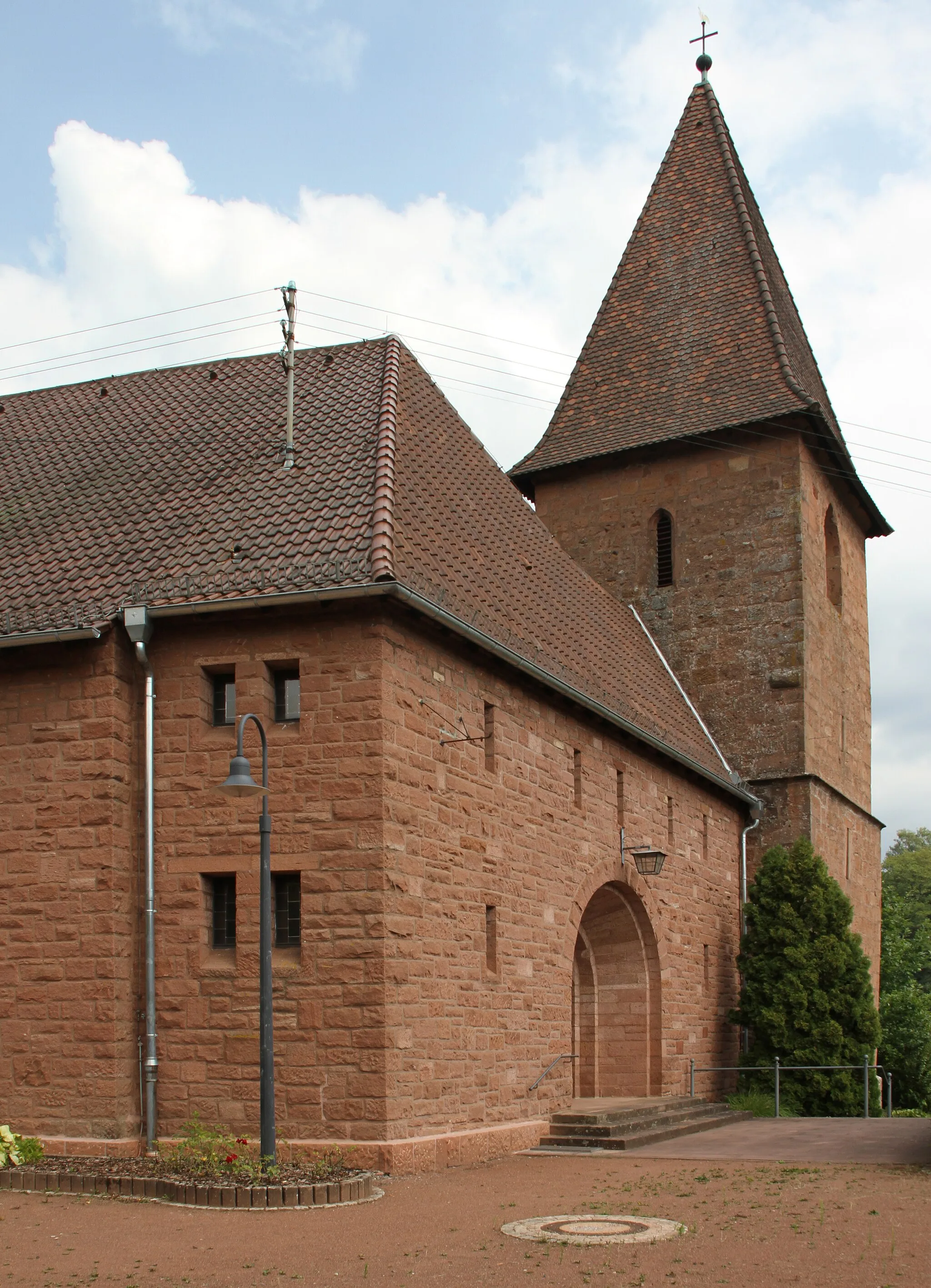 Photo showing: Niederschlettenbach, katholische Pfarrkirche St. Laurentius, Kirchstraße 10; Chor um 1220, Turm aus dem 15. Jahrhundert, einbezogen in den Neubau von 1952; barocker Kreuzsockel, bezeichnet 1783.