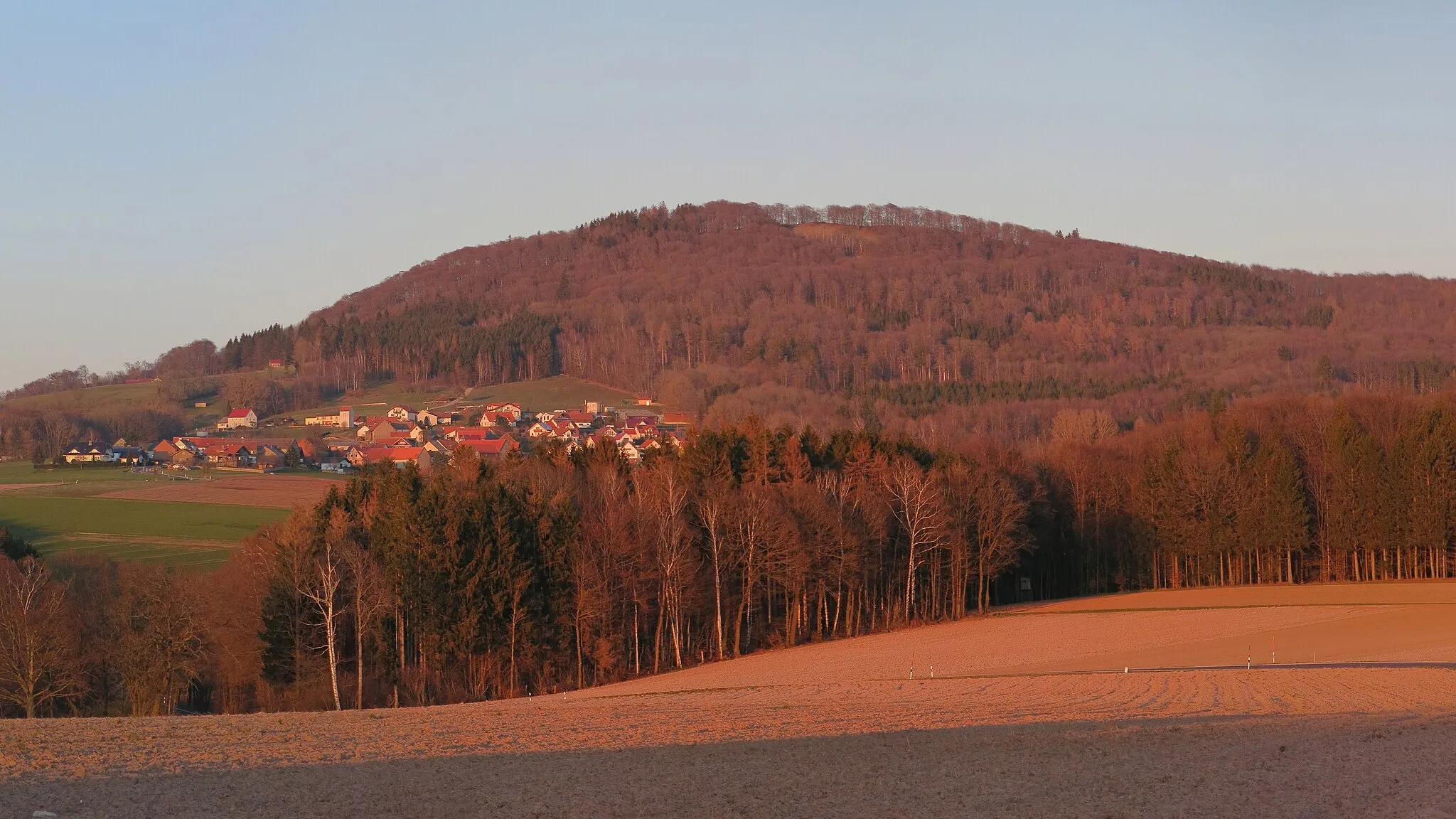 Photo showing: The Stellberg in the Rhön Mountains near Dipperz, seen from the west.  In front of the mountain the village of Wolferts.