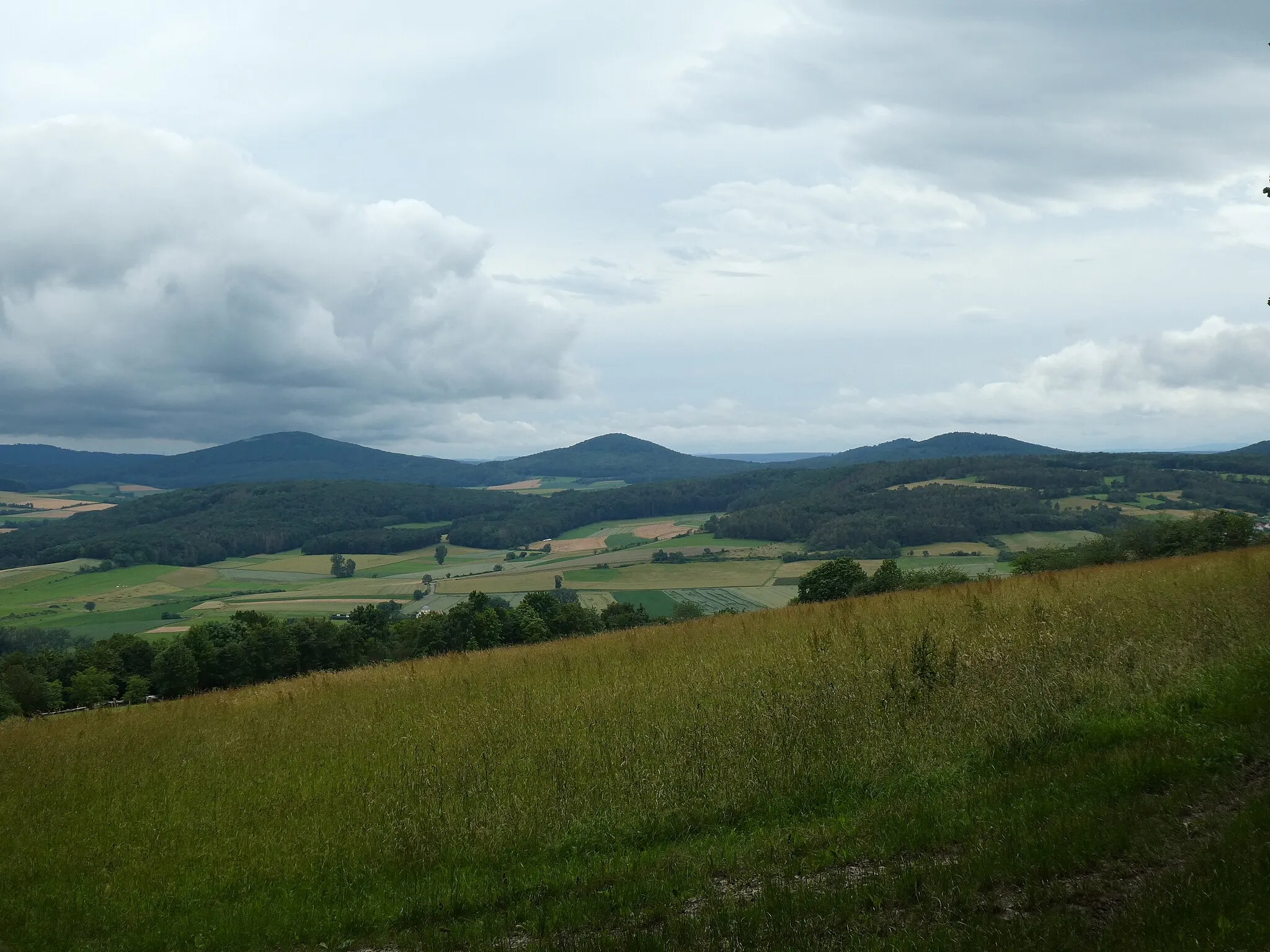 Photo showing: Blick von der Flanke des Soisbergs zum Trio Rückersberg, Appelsberg und Stallberg (Hessisches Kegelspiel, Soisberger Kuppenrhön). Davor die Hügel Steiger (links) und Hünberg.