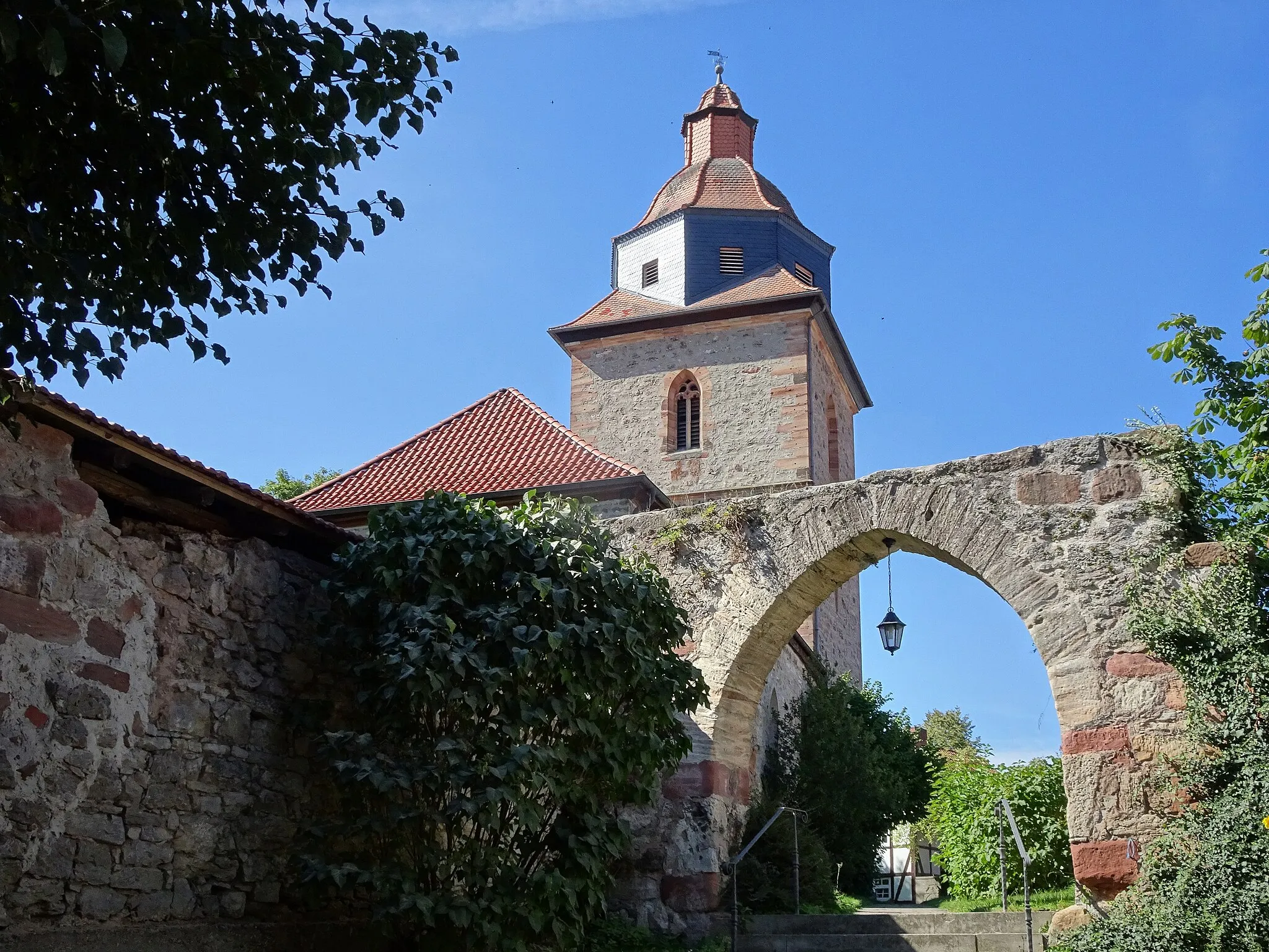 Photo showing: Ringgau-Röhrda im nordhessischen Werra-Meißner-Kreis.
"Die Kirche erhebt sich an exponierter, erhöht liegender Stelle im Ortsbild in direkter Nachbarschaft zum Gutshof. Der erhaltene mächtige Westturm datiert in das Jahr 1508, der Turmaufsatz mit Haubenlaterne wurde um 1700 aufgesetzt.
...
Der stattliche Außenbau besticht durch den hochaufragenden Turm, dessen Fachwerkaufbau die Ortssilhouette weithin bestimmt. Der das Gebäude umgebende Kirchhof bot mit seiner starken Ummauerung der Bevölkerung in Notzeiten sicheren Schutz."
Text aus: Denkmaltopographie Bundesrepublik Deutschland, Kulturdenkmäler in Hessen.
Werra-Meißner-Kreis I, Altkreis Eschwege.
Peer Zietz, Thomas Wiegand, Braunschweig: Vieweg Verlag, 1991, ISBN 3-528-06240-1.

Durch Röhrda führen der Herkules-Wartburg-Radwanderweg und der Elisabethpfad.