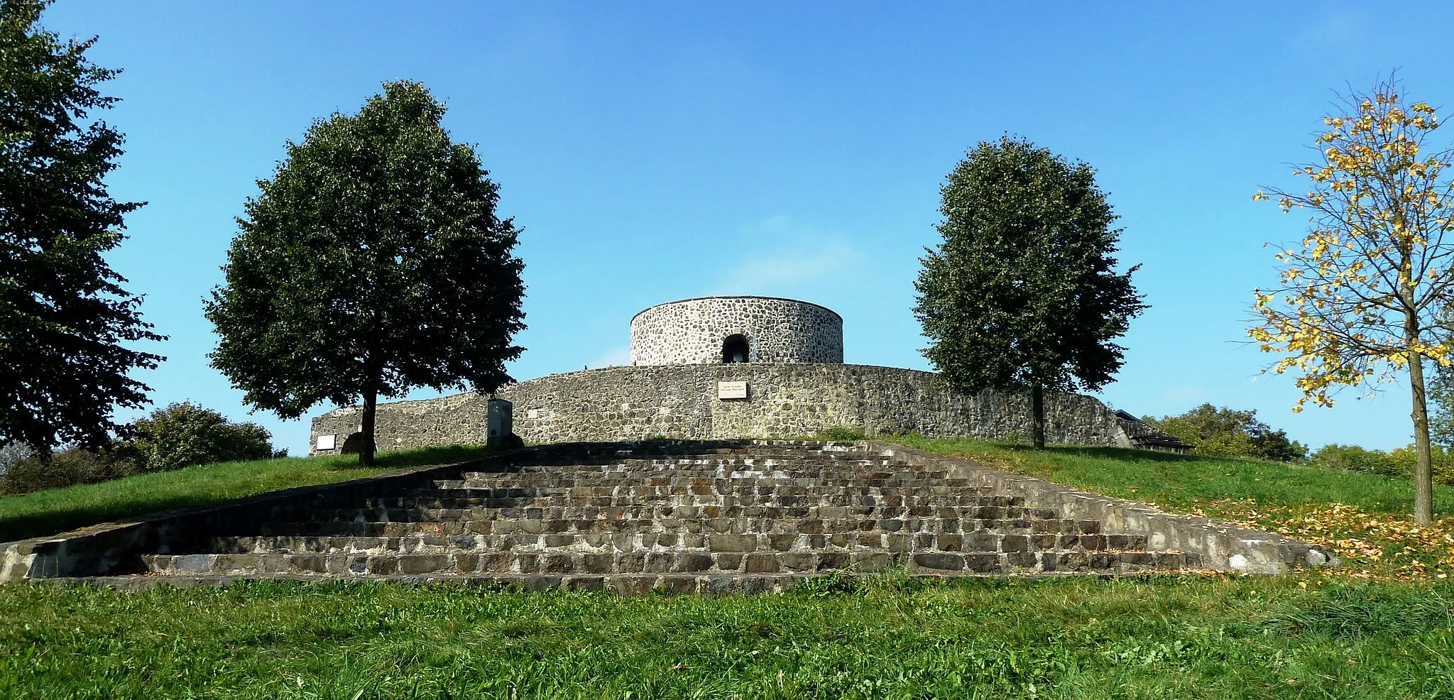 Photo showing: Ansicht des Turms der teilrestaurierten Ruine Heiligenburg auf dem Heiligenberg. Im Vordergrund befindet sich eine Freitreppe, auf der in jüngster Vergangenheit Theaterstücke aufgeführt wurden. Der Heiligenbergverein kümmert sich um die Pflege und Erhaltung der Anlage.