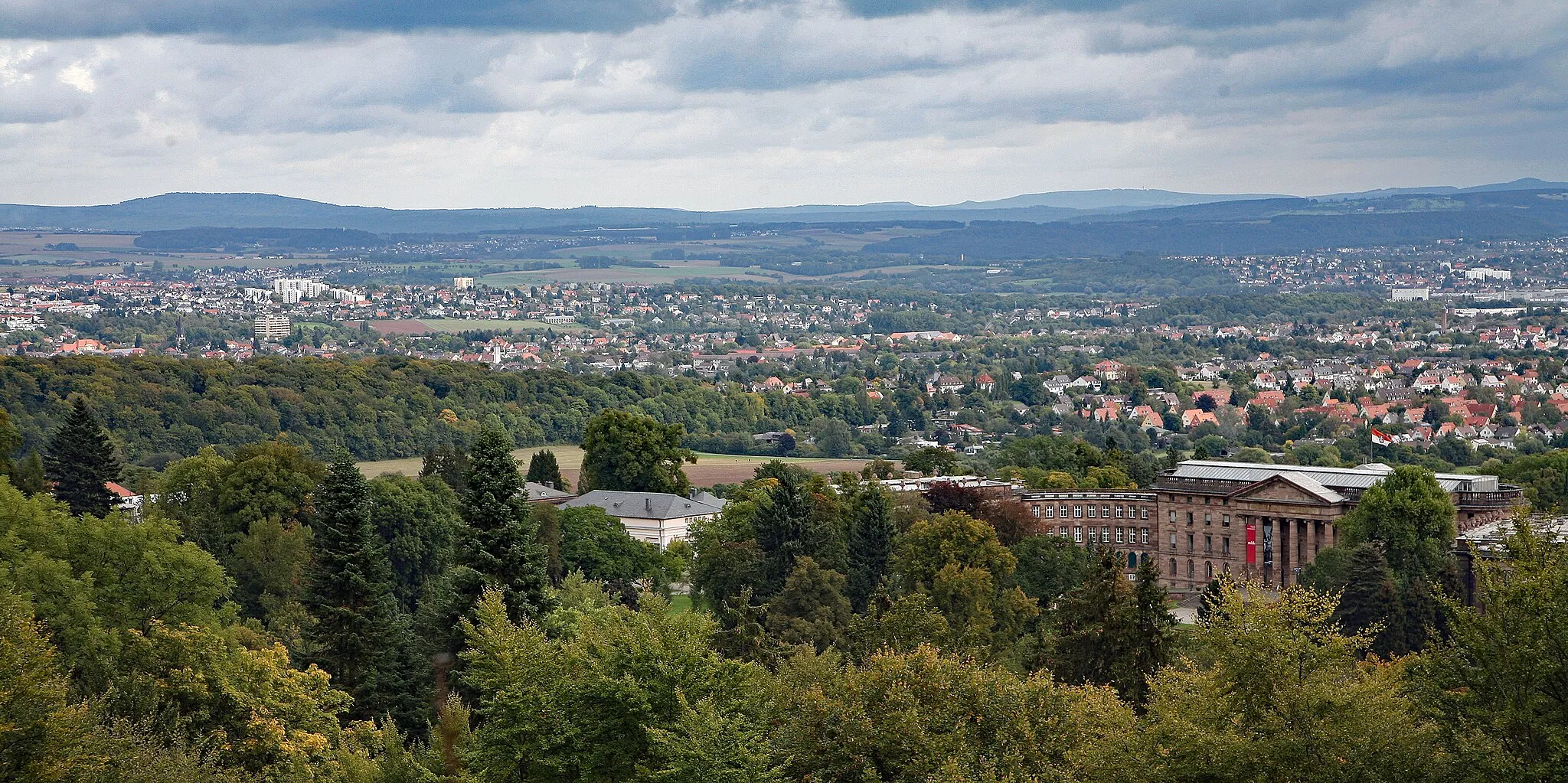 Photo showing: Blick vom Bergpark Wilhelmshöhe auf das Schloss Wilhelmshöhe und auf die Stadt Kassel. Im Hintergrund der Reinhardswald, der Kaufunger Wald und das Sölzinger Gebirge.