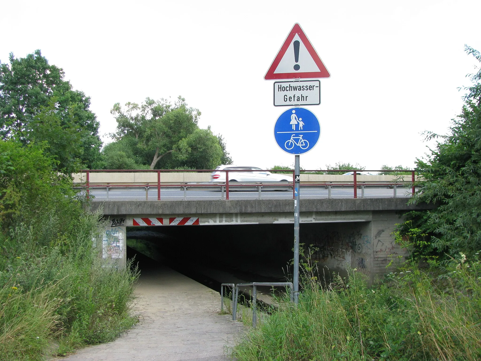 Photo showing: bei der Unterführung des Grunnelbach unter dem Autobahnzubringer verläuft ein Fuß- und Radweg, der bei einem Hochwasser des Bachs nicht passierbar ist