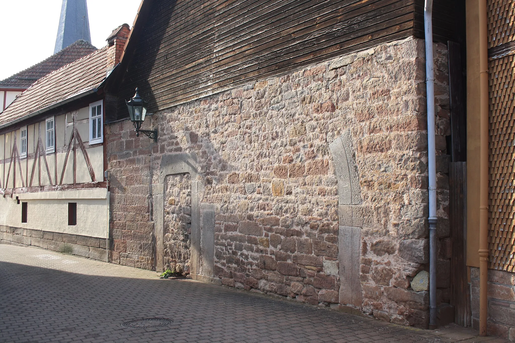 Photo showing: Sandsteinmauer mit erhaltenem Torbogen nahe dem Rathaus von Poppenhausen
