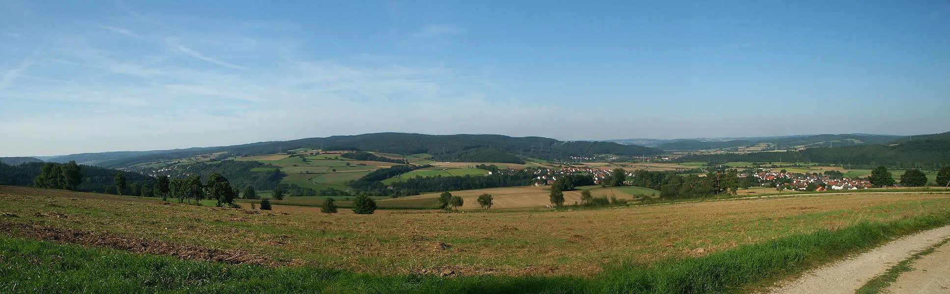 Photo showing: Panorama von Ludwigsau; Rechts erkennt man das Fuldatal, mit Bebra am Horizont, links steigt das Rohrbachtal in das Knüllgebirge an. Vorne rechts ist der Ortsteil Friedlos, weiter in der Bildmitte der Ortsteil Reilos und unterhalb der Anhöhe der Ort Mecklar. Ganz links außen im Rohrbachtal erkennt man die ersten Häuser der Ortes Rohrbach.