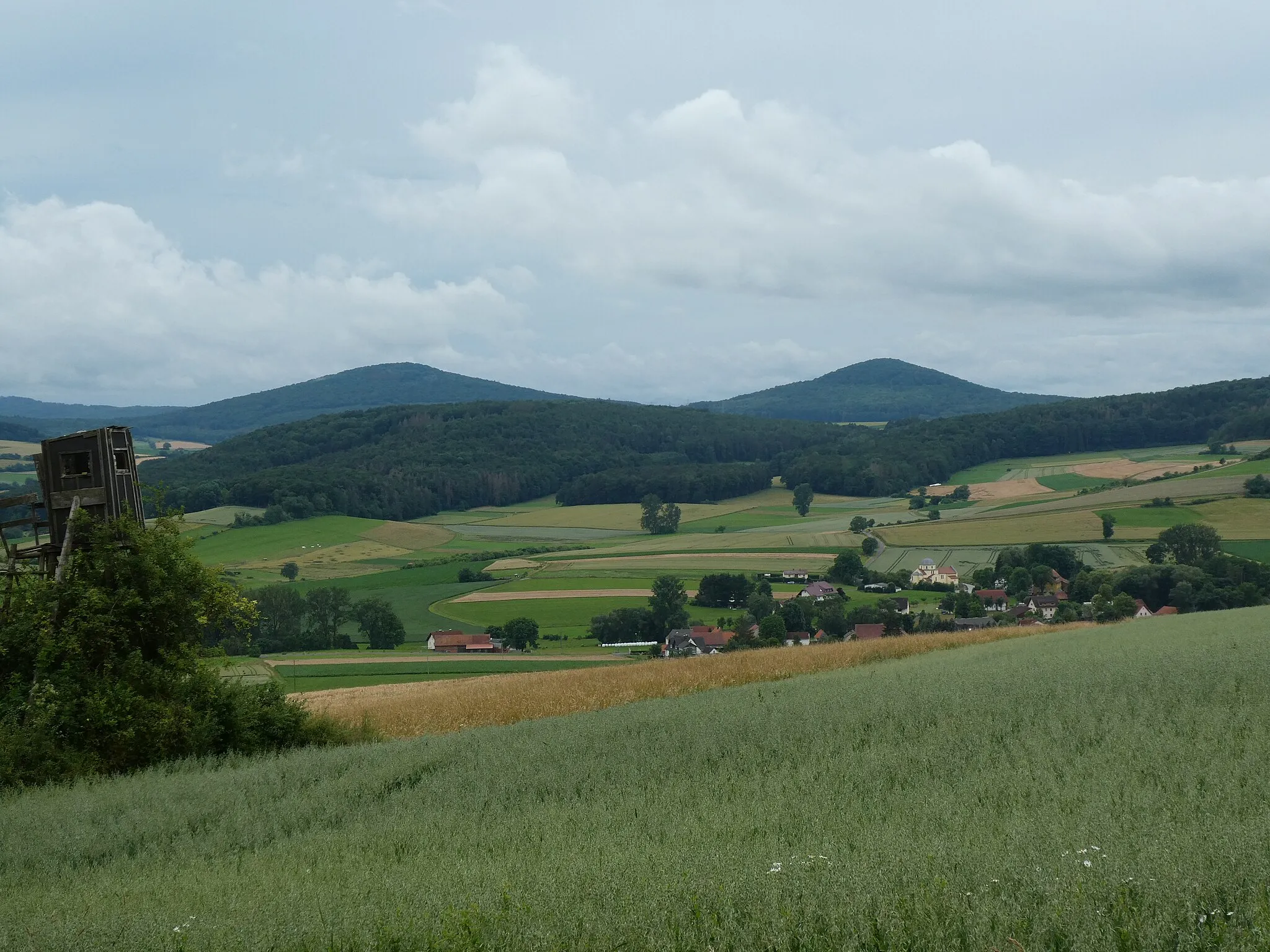 Photo showing: Blick von der Flanke des Soisbergs südwestwärts auf Rückersberg und Appelsberg, davor der Hügel Hünberg und Teile der Ortschaft Ufhausen