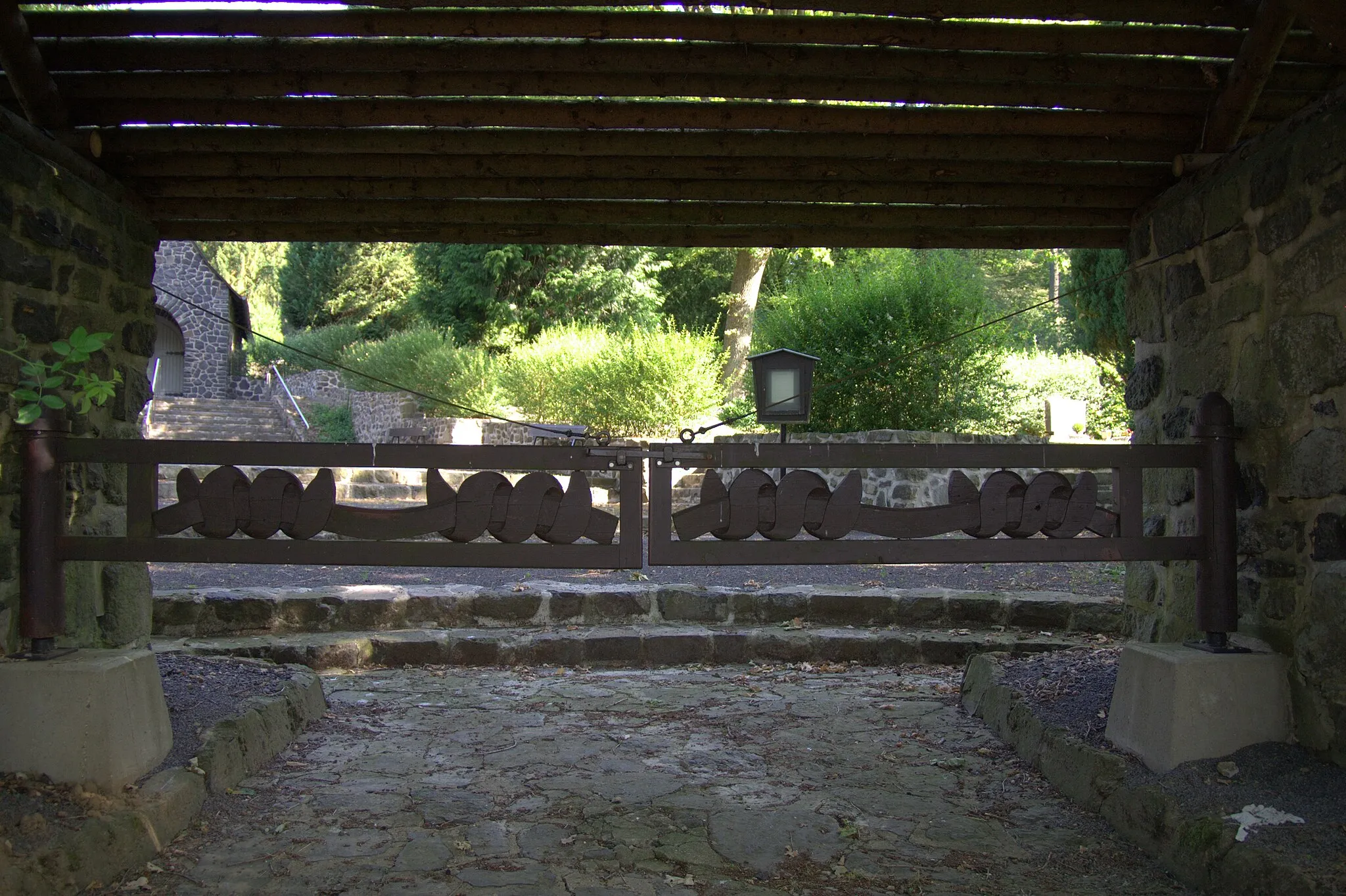 Photo showing: Das Eingangstor zum ehemaligen Friedhof des Stalag IX A Ziegenhain und zum heutigen Gemeindefriedhof Trutzhain. Das Eingangstor wurde zwischen 1940 und 1945 von unbekannten französischen Kriegsgefangenen angefertigt