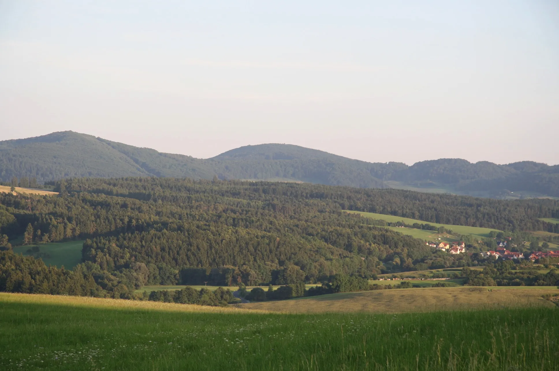 Photo showing: Blick vom Gebiet zwischen Rasdorf und Wiesenfeld südsüdostwärts zum Seelesberg (Mitte) und zum Boxberg (rechts). Am Seelesberg ist noch der Grenzverlauf zwischen DDR und BRD erkennbar. Rechts ein Teil des Ortes Geismar.