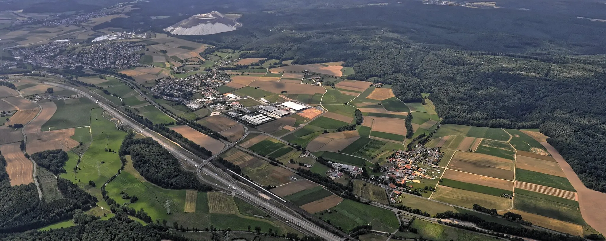 Photo showing: Bilder vom Flug Nordholz-Hammelburg 2015: Blick auf die Bundesautobahn A 66 mit Tiefengruben (vorn rechts), Dorfborn (Mitte) und Neuhof bei Fulda (links). Die Kalibergbauabraumhalde "Monte Kali" am oberen Bildrand links.