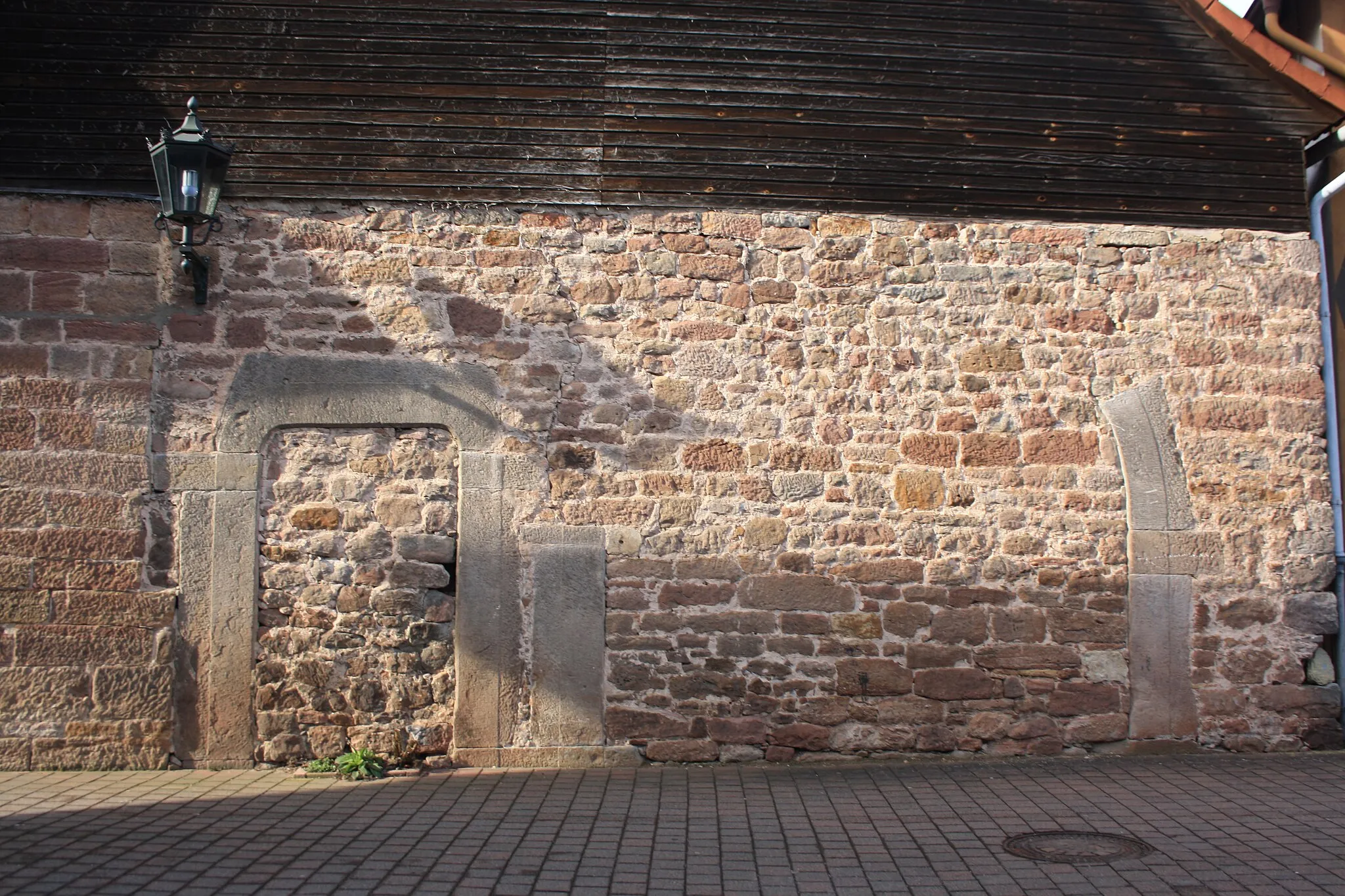 Photo showing: Sandsteinmauer mit erhaltenem Torbogen nahe dem Rathaus von Poppenhausen