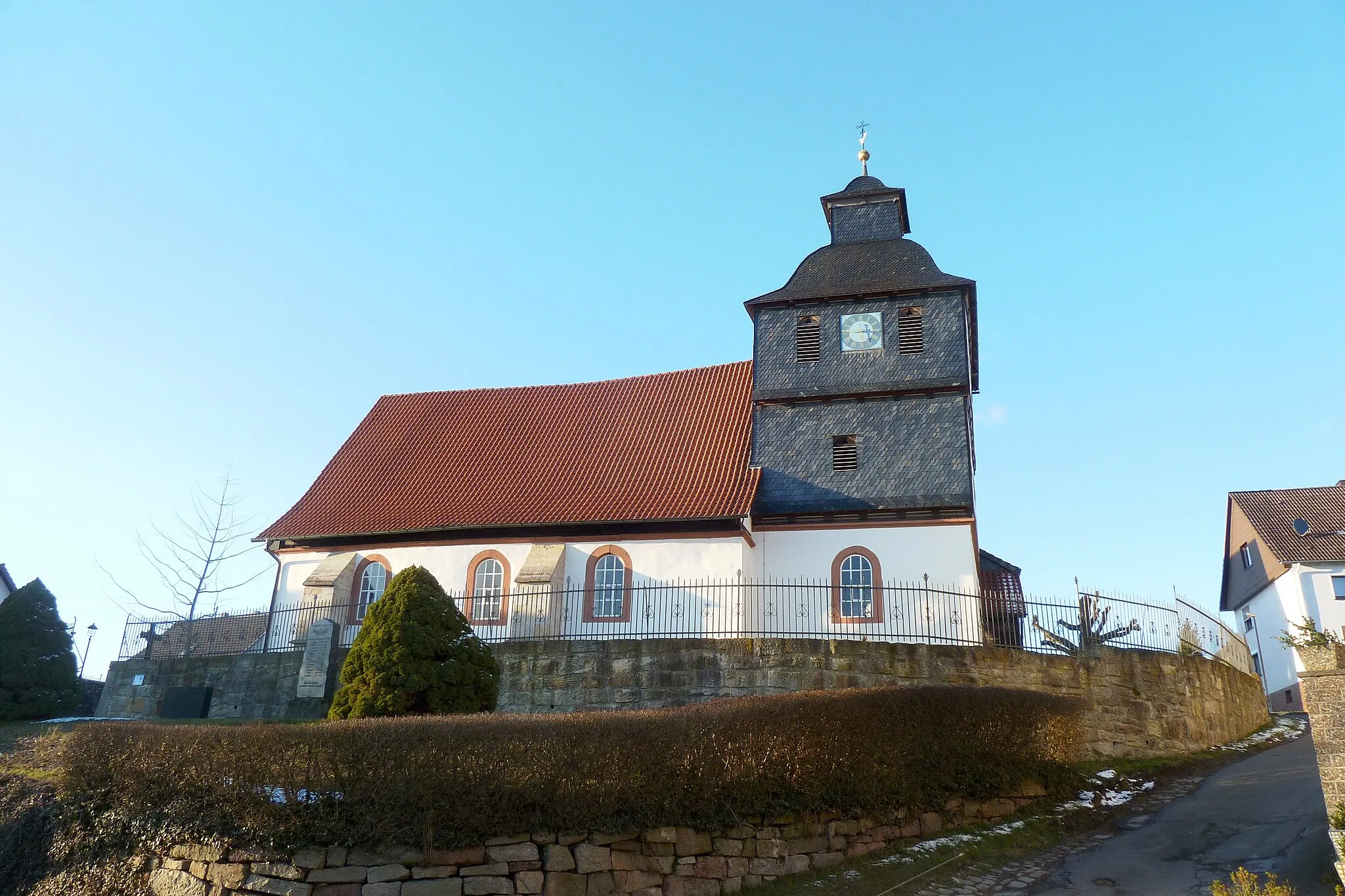 Photo showing: Ev.-luth. Kirche in Escherode, Gemeinde Staufenberg, Südniedersachsen. 1425 erstmals urkundlich erwähnt, Untergeschoss des Chortums mit Rippengewölbe vermutlich 15. Jh. mit Wandmalereifragmenten des 14./15. Jahrhunderts lt. Denkmaltopographie. Tumobergeschosse jünger aus Fachwerk, teils verschiefert. Fenster- und Türöffnungen mit Werksteineinfassungen ebenfalls jünger, Nordportal dat. 1720