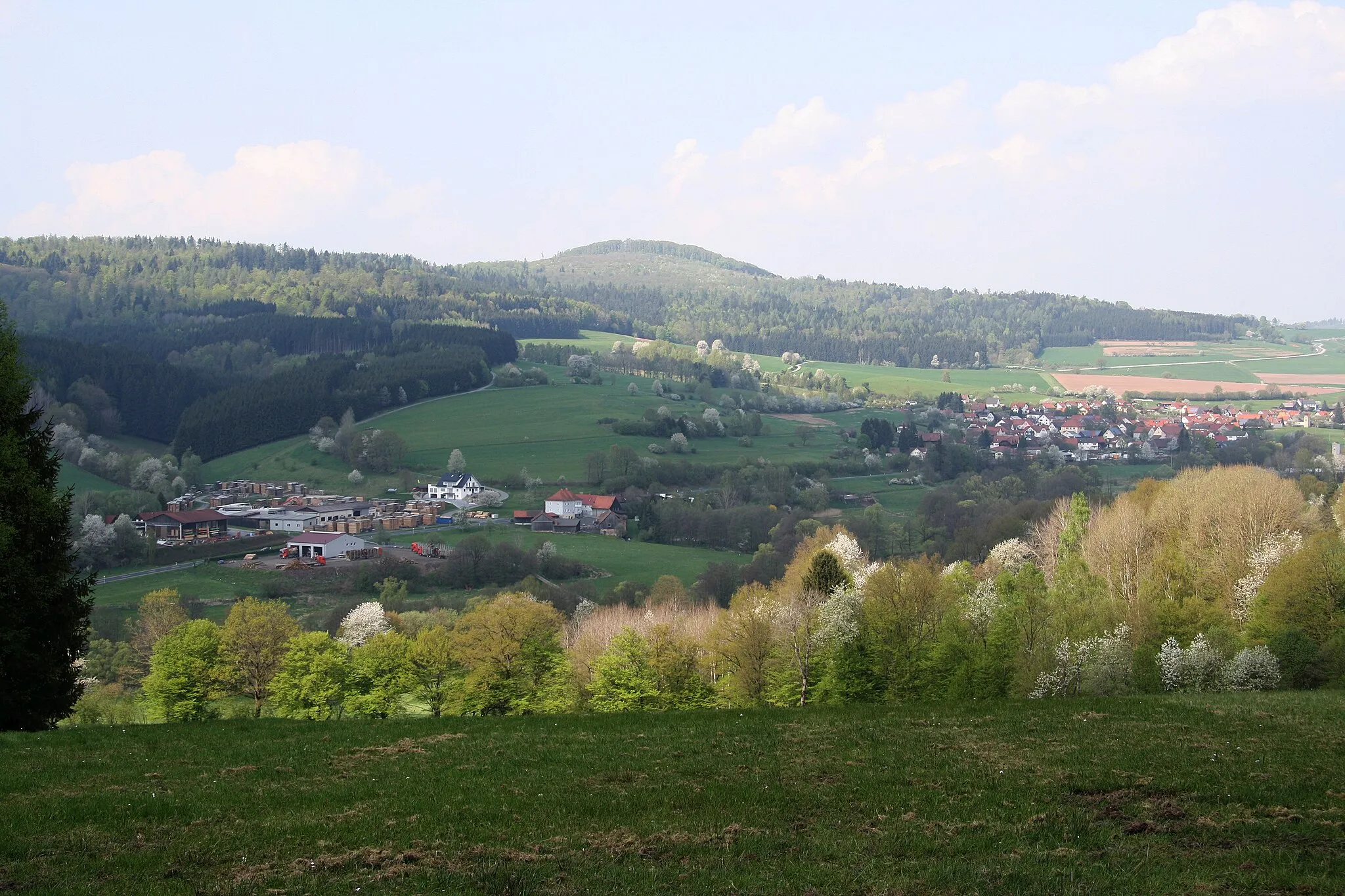 Photo showing: Blick vom Gebiet östlich von Speicherz etwa nordnordwestwärts zur Großen Haube. Die Ortschaft links heißt Eisenhammer, rechts Kothen. Gemeinde Motten, Landkreis Bad Kissingen, Bayern