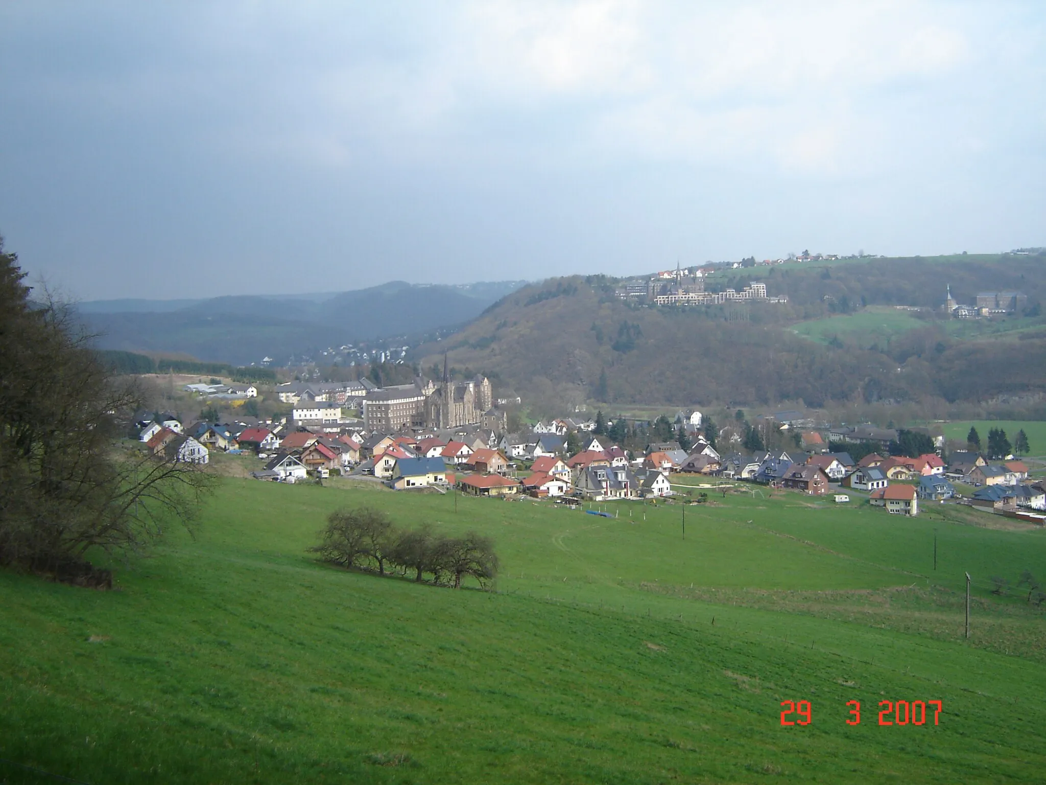 Photo showing: Hausen im Jahre 2007, im Hintergrund ist Waldbreitbach zu erkennen, oben rechts das "Marienhaus Waldbreitbach" sowie im Hintergrund auf dem Berg ist Breitscheid-Hochscheid zu sehen.