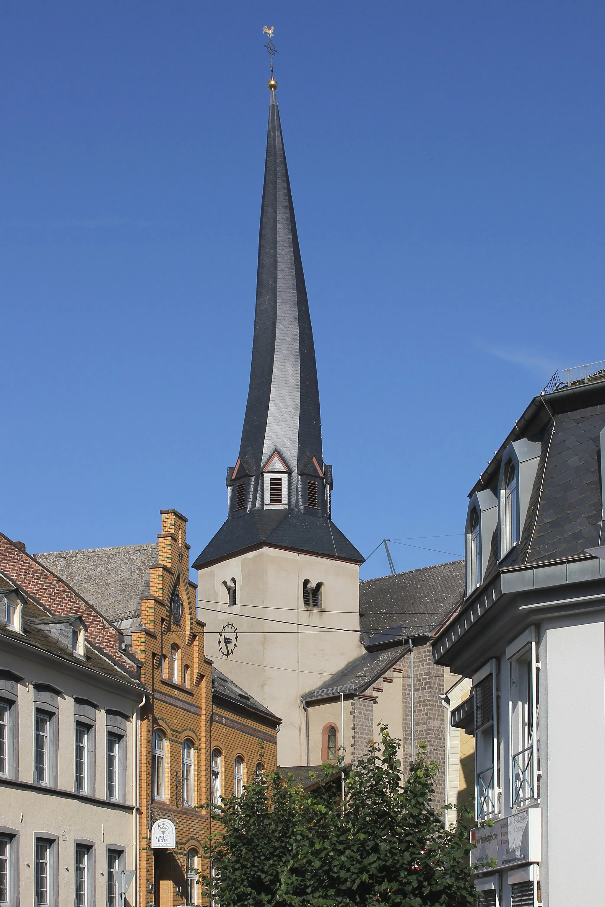 Photo showing: Glockenturm der Pfarrkirche St. Pankratius in Kaisersesch, erbaut im frühen 14. Jahrhundert und in den Neubau von 1899/1900 einbezogen. Die Konstruktionshölzer des etwa 24 Meter hohen Turmhelms sackten zusammen, wodurch die auffällige Drehung entstand. Diese ursprünglich durch einen Konstruktionsfehler entstandene typische Form wurde 2014 bei der Erneuerung des Turmdachstuhls originalgetreu rekonstruiert.