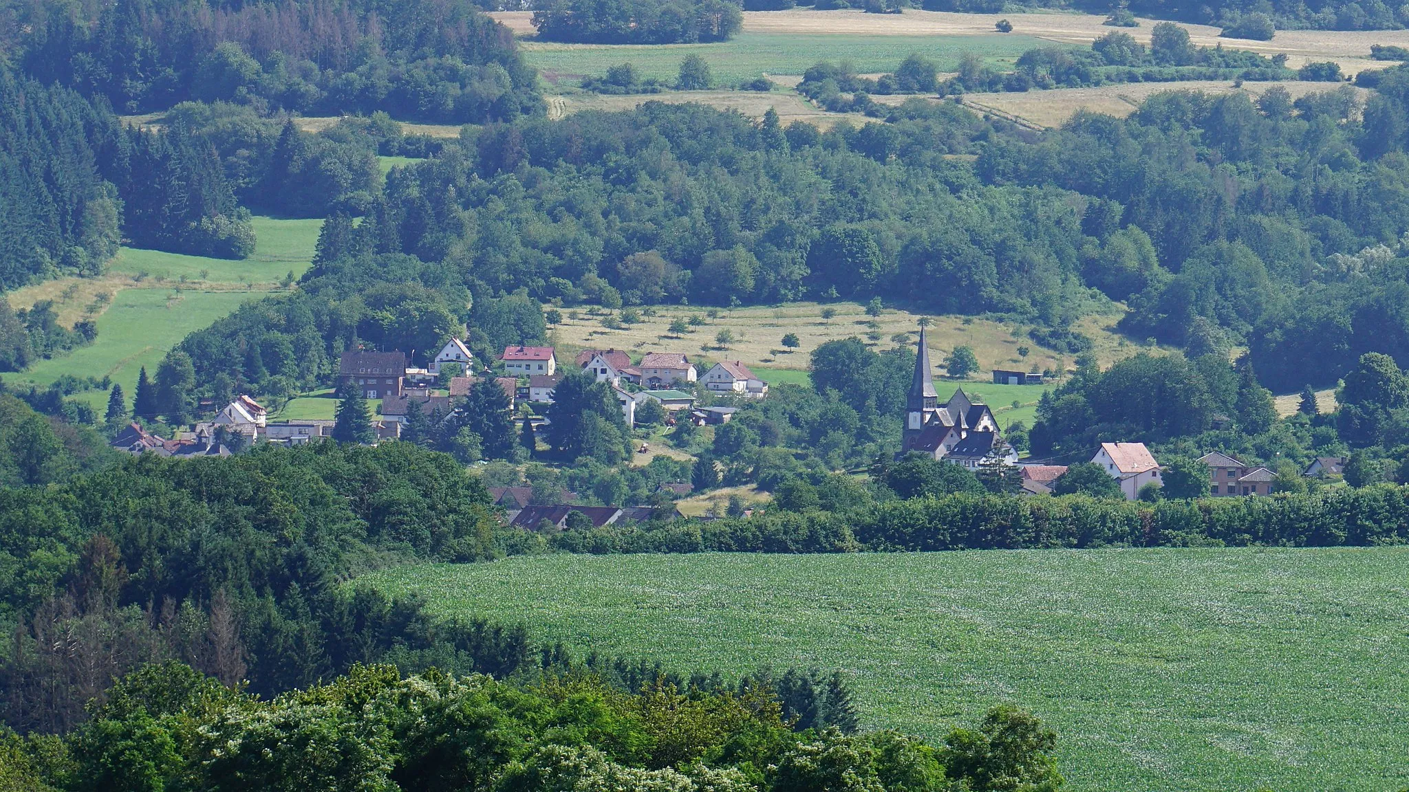 Photo showing: View of Berglangenbach in the Rhineland-Palatinate district of Baumholder. In the right half of the picture you can see the church of Berglangenbach.