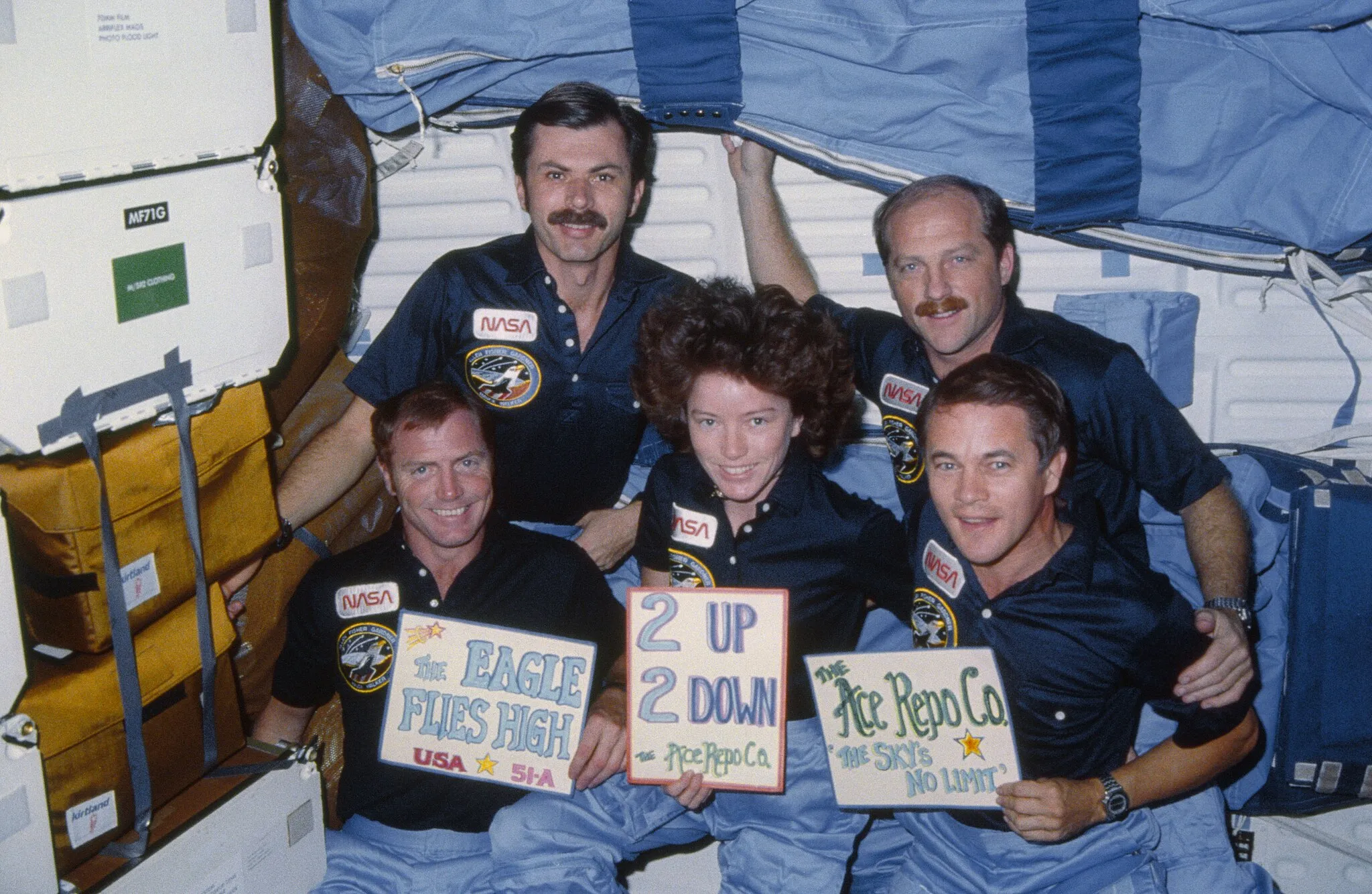 Photo showing: 51A-13-028 (12 Nov 1984) --- The five-member crew celebrates a successful mission. The reference to the eagle has to do with the Discovery crew’s  mascot, which appeared both in its crew portrait and insignia.  L-R (front row) astronauts David M. Walker, Anna Lee Fisher and Joseph P. Allen; (back row) Dale A. Gardner and Frederick H. (Rick) Hauck.