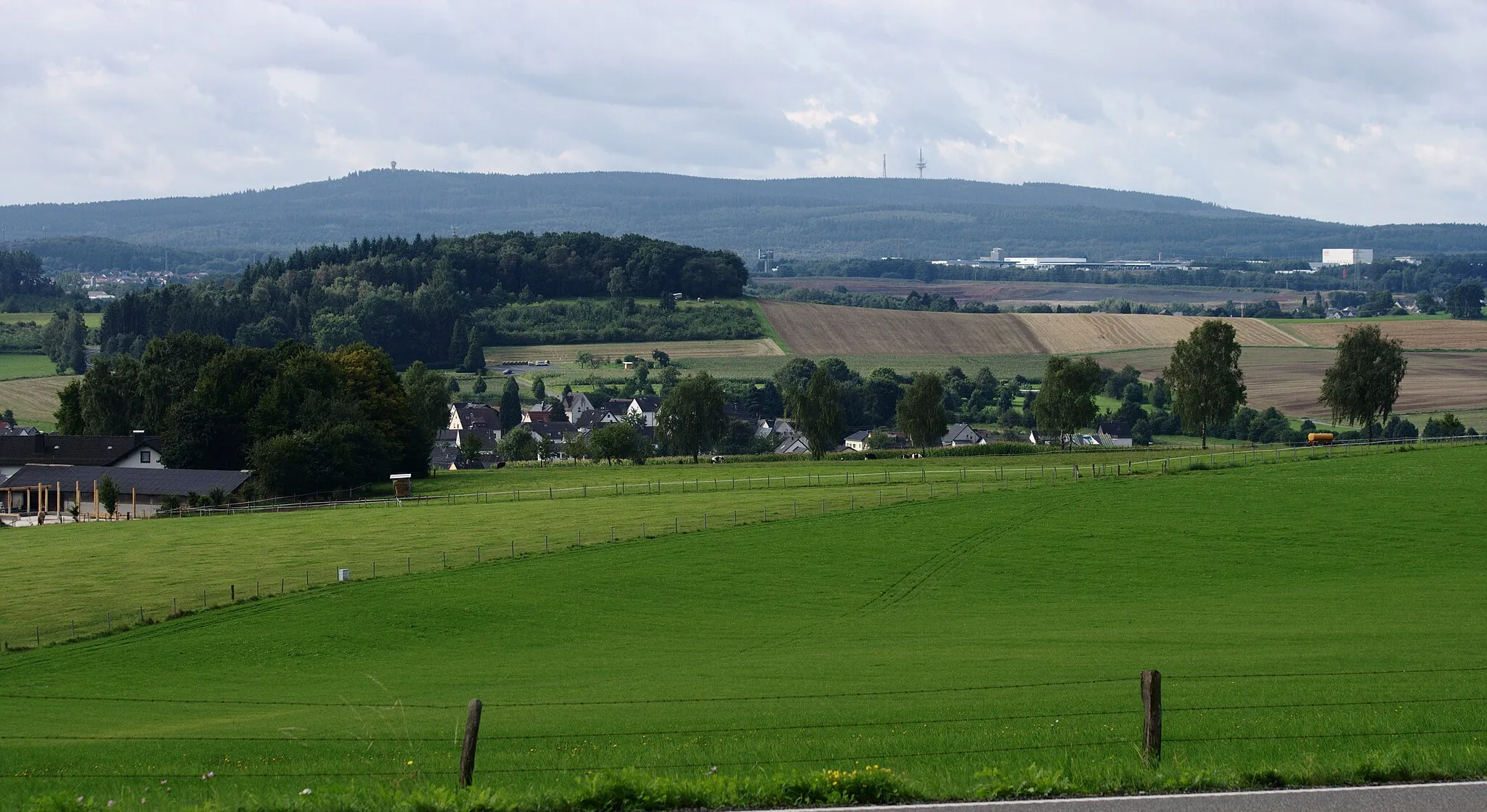 Photo showing: View from north to Montabaurer Höhe mountain range in Westerwald, Germany. On the left lookout tower "Köppel" and on the right two communication towers at Alarmstange mountain. Seen from near Vielbach village. In the foreground Vielbach and Lanzenberg hill.