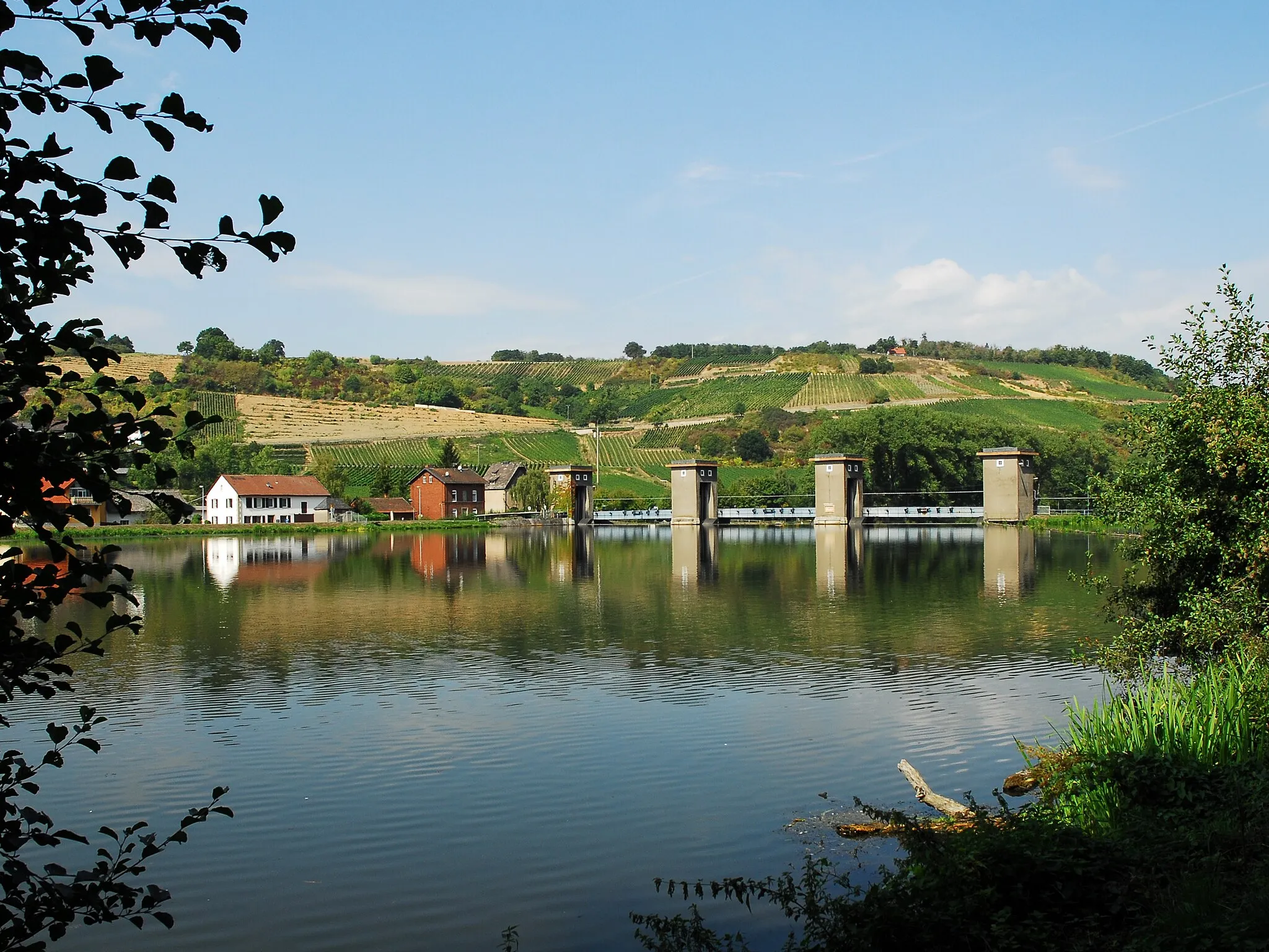 Photo showing: Stausee in Niederhausen (Nahe), östlich des Ortes an der Nahe: Blick von Ostufer auf die Wasserfläche des Stausees und das Stauwehr.