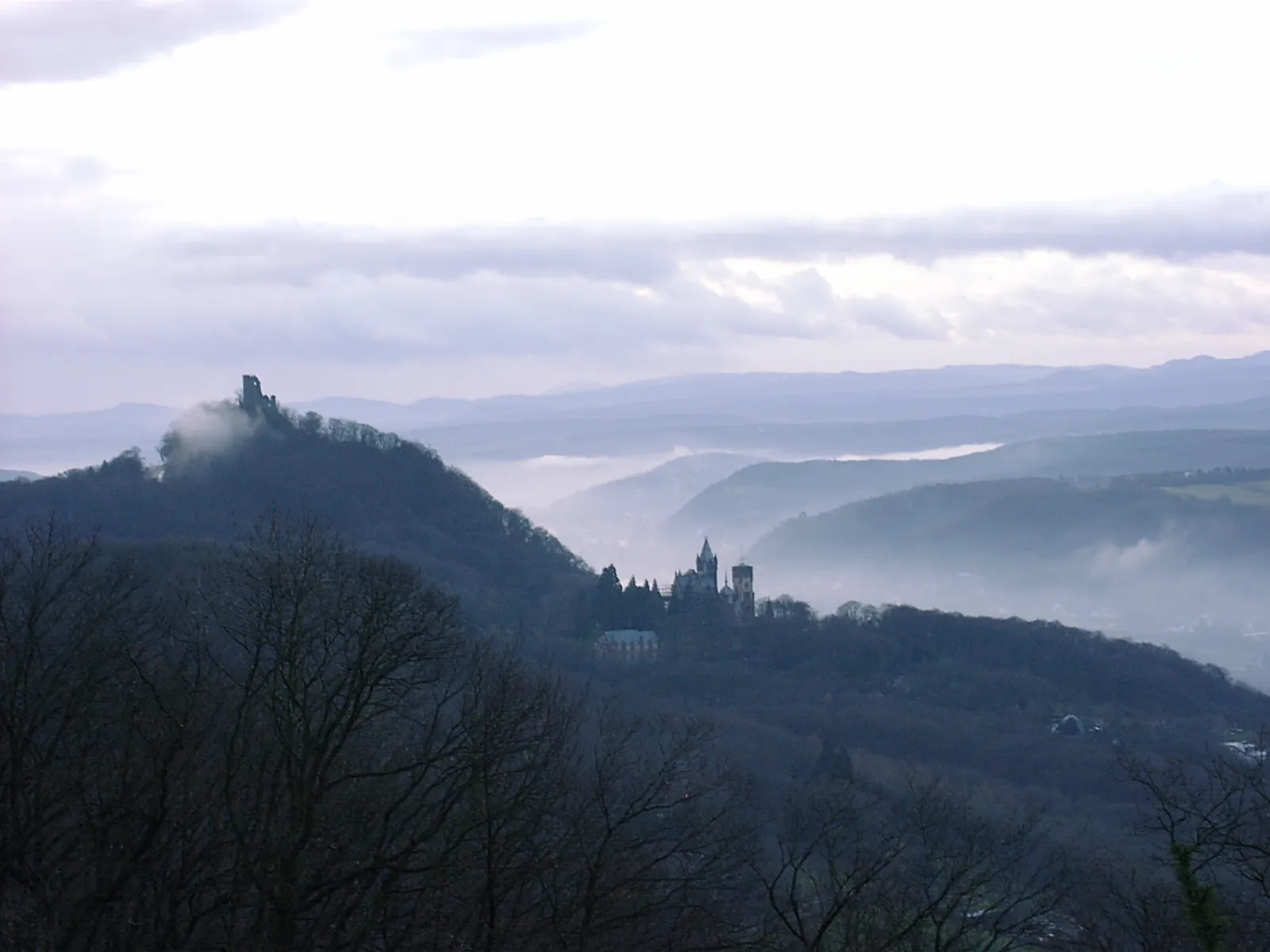 Photo showing: Dawn view from Petersberg into Rhine valley (left hand the ruined castle Drachenfels, in the middle the so-called Schloss Drachenburg)