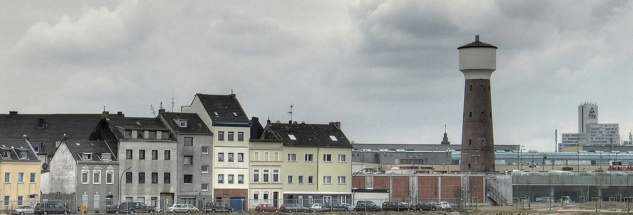 Photo showing: Cologne-Kalk CFK Watertower

Description in German: Der historische Wasserturm der ehemaligen Chemischen Fabrik Kalk umbaut von den KölnArcaden, links typische Kalker Altbauhäuser, die nach den Zerstörungen im Zweiten Weltkrieg in Schlichtbauweise wiederaufgebaut wurden