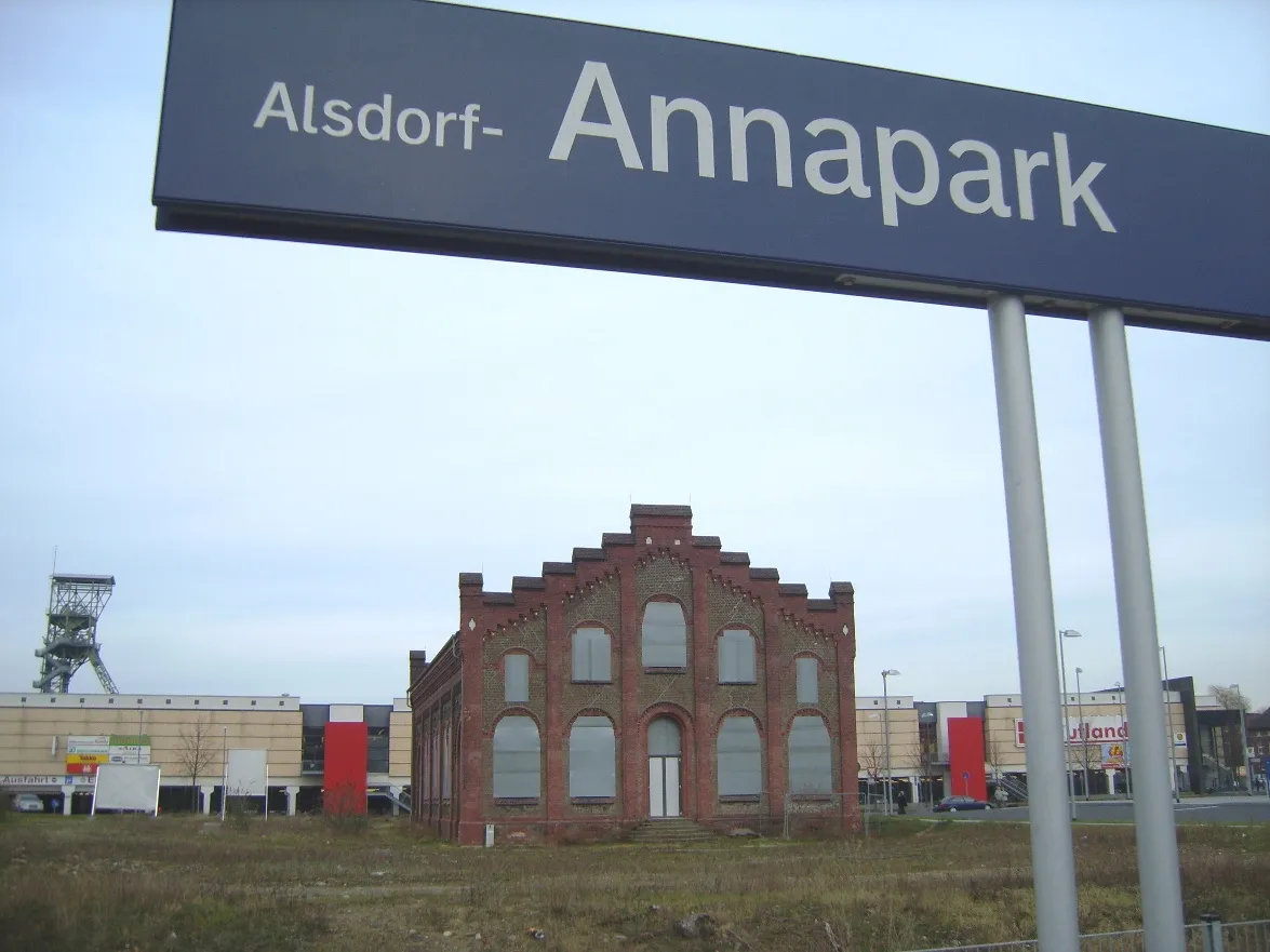 Photo showing: Euregiobahn-Haltepunktschild Alsdorf-Annapark mit Förderturm und Zechengebäude im Hintergrund