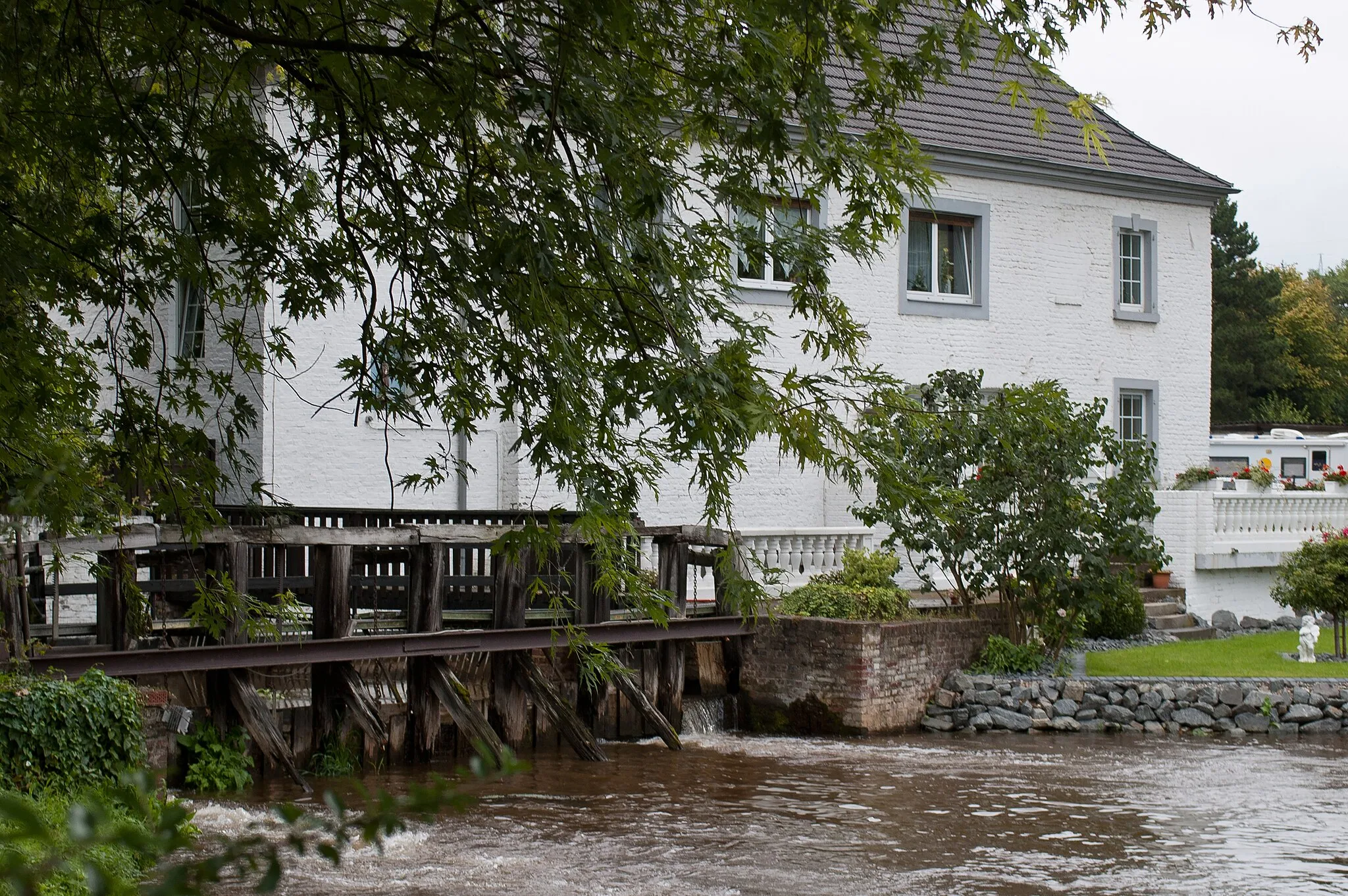 Photo showing: Die Zievericher Mühle, frühere wasserkraftbetriebene Korn- und Ölmühle, in Bergheim-Zieverich. Hofabgewandte Seite des eigentlichen Mühlengebäudes mit Stauwehr.