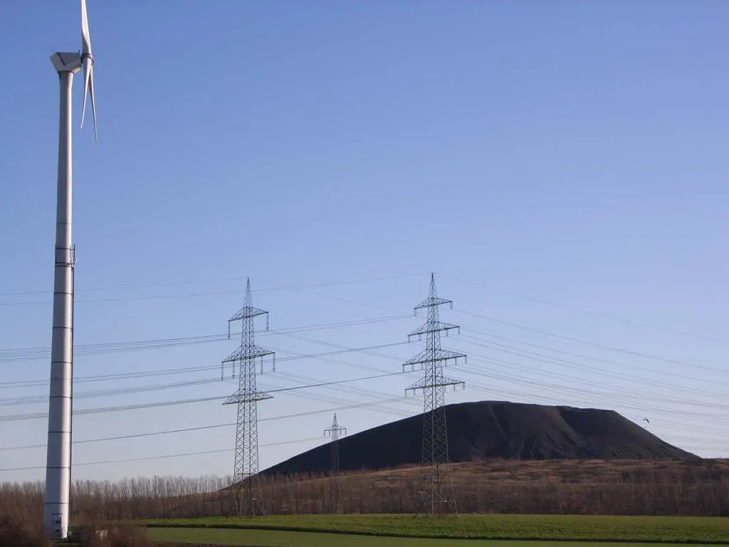 Photo showing: Halde der Grube Emil-Mayrisch in Baesweiler zwischen Siersdorf und Puffendorf (Westseite) mit Windkraftanlage, Strommasten und Gleitschirmsegler; Freileitungen 380 kV, Bahnstrom und 110 kV (links nach rechts)