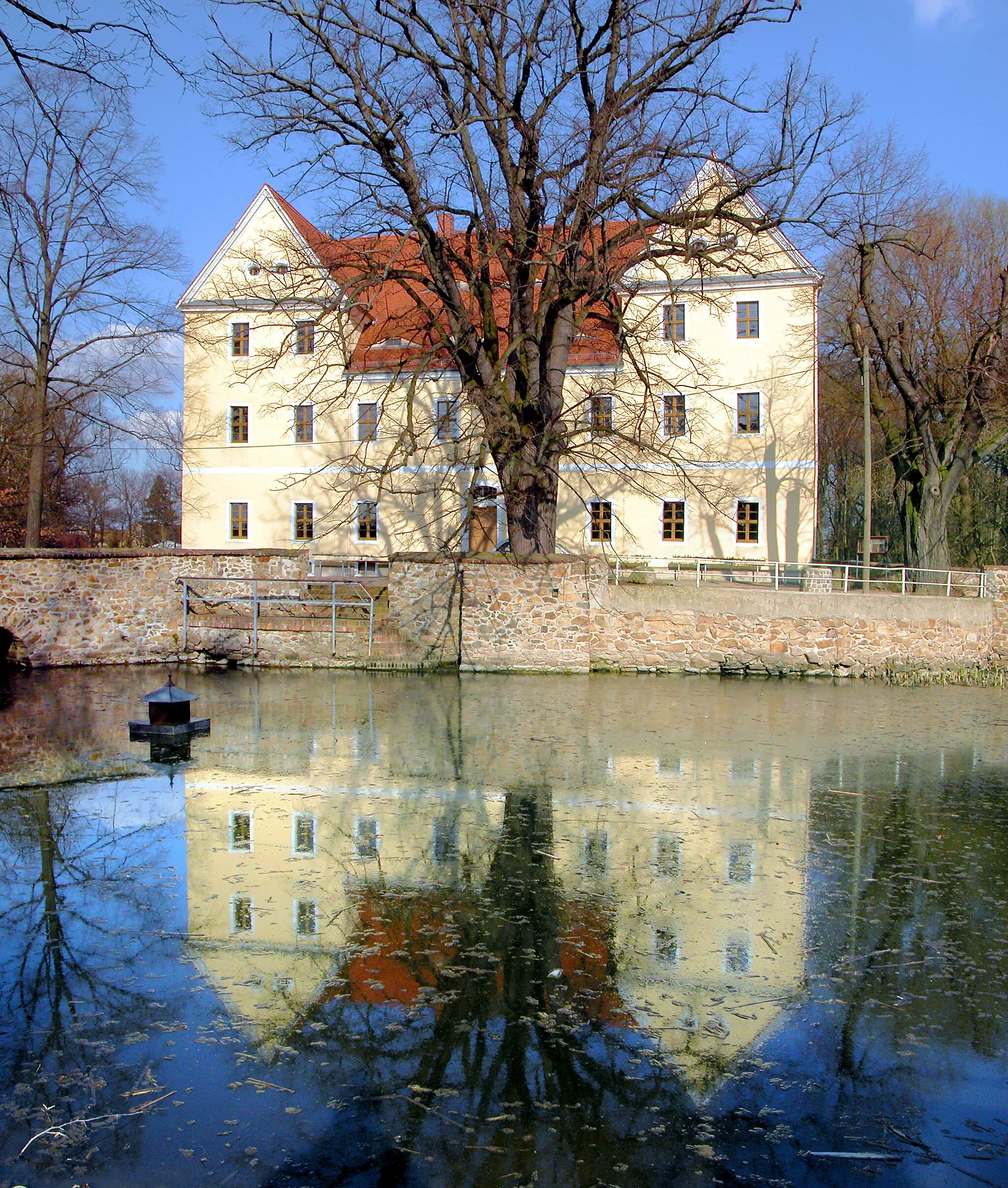 Photo showing: 23.03.2012  04808  Röcknitz (Thallwitz), An der Wasserburg 3 (GMP: 51.450828,12.780060): Das Herrenhaus Röcknitz ist aus einer mittelalterlichen Wasserburg entstanden. Am hofseitigen Portal ist die Jahreszahl 1696 vermerkt. Im Schlußstein sind die Wappen der Familien von Plötz und von Birkholz zu sehen. Das kaum noch lesbare Monogramm I. P. C. A. V. B. verweist auf Joachim von Plötz und seine Frau Catharina Agnes von Birkholz. Seit 2004 wird das Gebäude als Vereinshaus und "Geoportal" genutzt.                                                                                                   [DSCNn3505-3505.TIF]20120323605MDR.JPG(c)Blobelt