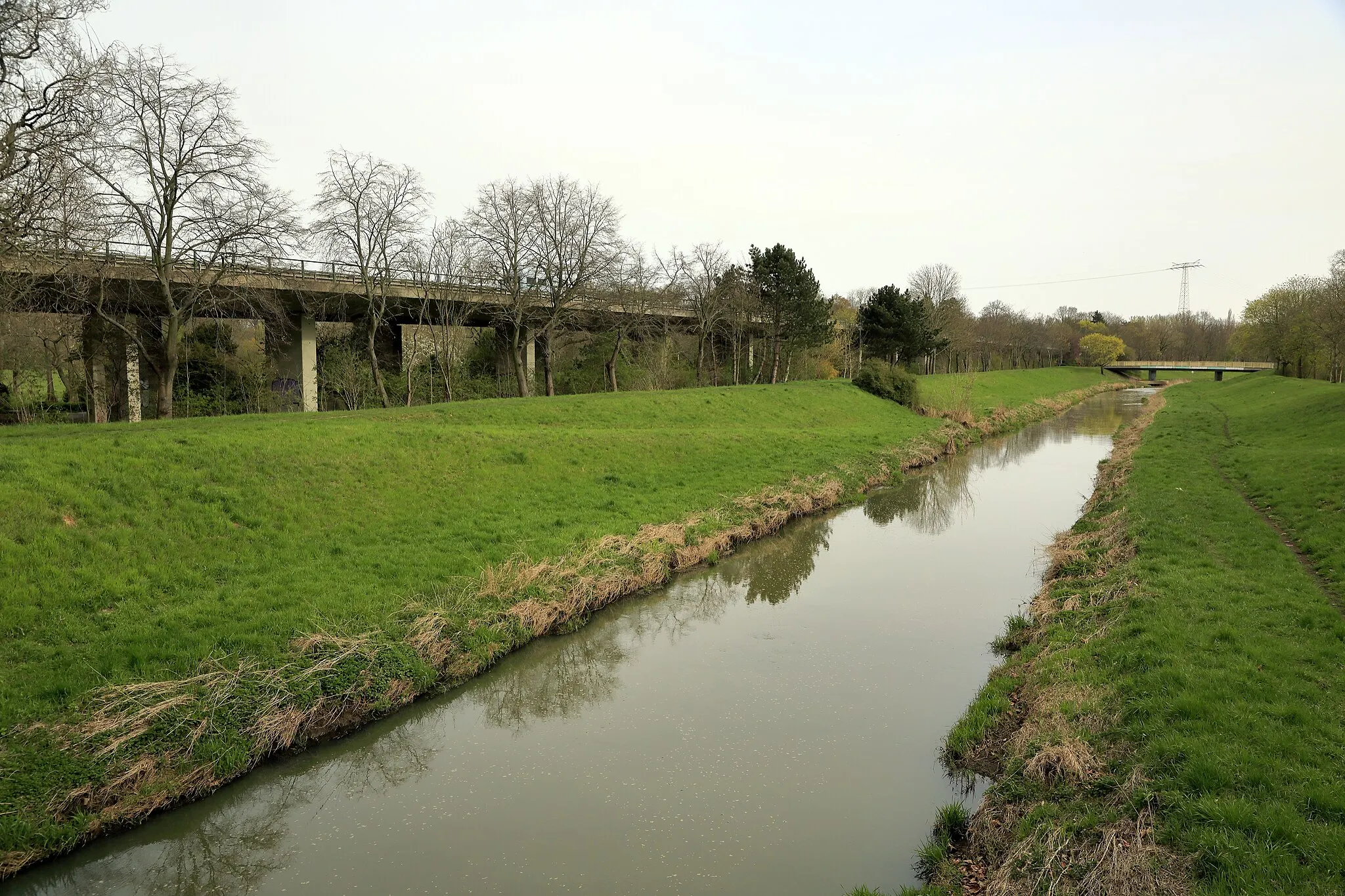 Photo showing: Die Pleiße musste in den 1970ern gemeinsam mit den Fernverkehrsstraßen 2 und 95 als Ersatzmaßnahme für Unterbrechungen durch den Braunkohlenbergbau durch den ehemaligen Herfurth-Park neutrassiert werden.
Die Brücke wurde jedoch schon nach 2000 schadhaft. Die Folge war eine Geschwindigkeitsbeschränkung auf 60 km/h, ein Mindestabstand von 50 m für Lkw und Breitenbegrenzungen der Fahrbahnen. Zusätzlich wurden mehrere Öffnungen durch Hilfsstützen gesichert.