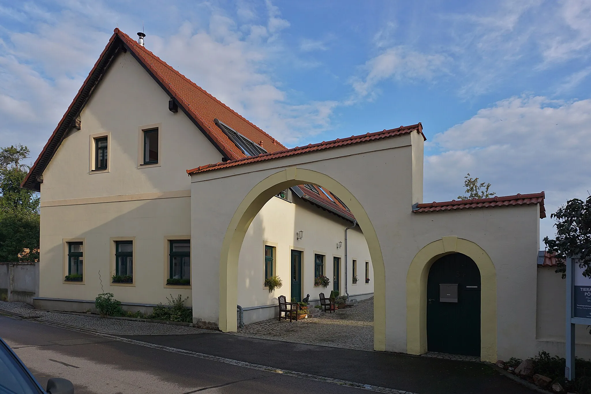 Photo showing: Wohnstallhaus und Toranlage (Torbogen und Pforte) eines ehemaligen Dreiseithofe. um 1800. Giebelständiges Wohnstallhaus mit Fachwerkobergeschoss, original erhaltene Teile eines Bauernhofes in ortsbildprägender Lage, baugeschichtlich und ortsgeschichtlich von Bedeutung.
Wohnstallhaus: Zwei Geschosse, Lehm- und Bruchsteinmauerwerk verputzt, Fachwerk-Obergeschoss mit Backstein und Lehmflechtgefachen, Dachstuhl alt, Fenstergrößen original, Fenster teilweise alt, Erdgeschoss Sandsteinfenstergewände, Stalltüren mit Flachbogen und Sandsteinrahmung, Verlängerung des Stalles weitgehend abgebrochen, Stall, Backstein- und Lehmmauerwerk, Fachwerk-Obergeschoss mit kleiner, jetzt verbretterter Oberlaube, Scheune: Fachwerk mit Lehmflechtwerk, zwei Rechtecktore mit Holzangeln, große gemauerte Toranlage mit Torbögen über Tordurchfahrt und Eingang, Abbruchgenehmigungen, Teilabbruch des Gehöfts (Scheune und Seitengebäude vor 2012 abgebrochen).