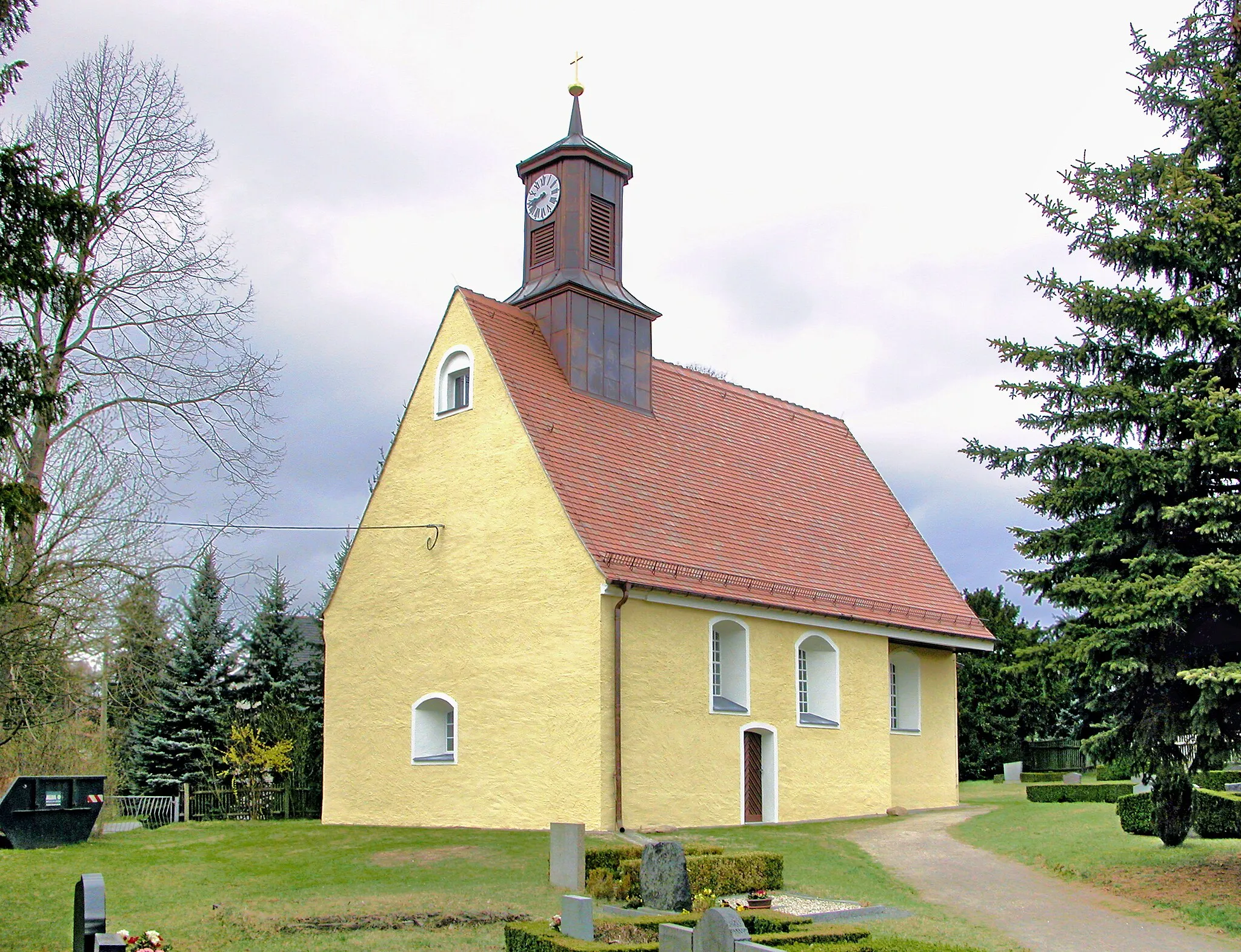 Photo showing: 02.04.2012  04774  Ochsensaal (Dahlen), An der Kirche: Die kleine romanische Dorfkirche (GMP: 51.416311,12.952859) stammt noch aus den Anfangsjahren der deutschen Besiedelung und lässt sich ins 12. Jahrhundert datieren. Die Saalkirche setzt sich aus einem kurzen Langhaus, einem eingezogenen Chor und der halbrunden Apsis zusammen. Die nördliche Chorwand wurde - wohl im 18. Jahrhundert - nach außen gesetzt. Dagegen ist auf der Südseite die Abstufung erhalten geblieben. Das steile Kirchendach geht einheitlich über Langhaus und Chor hinweg. EinenTurm hatte die Kirche ursprünglich nicht; der Dachreiter wurde erst 1842 aufgesetzt Aufnahme nach der Außensanierung.                                                                                                                                                                         [DSCNn3578.TIF]20120402140DR.JPG(c)Blobelt