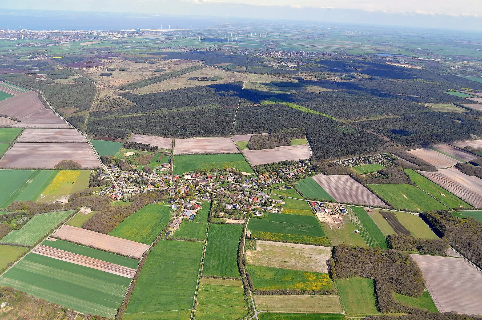 Photo showing: Luftbilder von der Nordseeküste 2012-05; die Ortschaft im Vordergrund ist der Stadtteil Berensch von Cuxhaven; das Waldgebiet dahinter mit den noch weiter dahinter liegenden Freiflächen gehört zu dem Naturschutzgebiet Cuxhavener Küstenheiden, die kleinen Wälder im Vordergrund gehören zu dem Naturschutzgebiet Eichenkrattwälder bei Cuxhaven, beide zusammen gehören zu dem FFH-Gebiet Küstenheiden und Krattwälder bei Cuxhaven