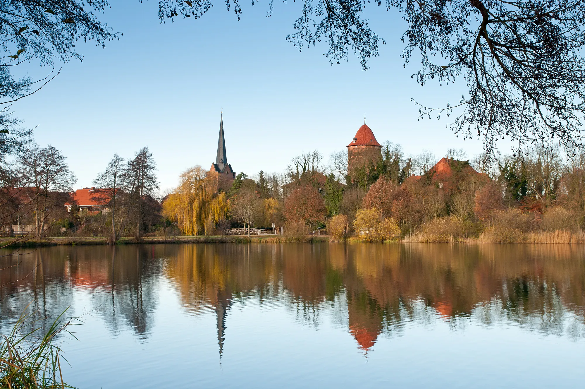 Photo showing: View from the lake "Thielenburger See" to the old town skyline of Dannenberg (Elbe) in late autumn. You can see both town landmarks, the church St. Johannis and the castle tower "Waldemarturm".