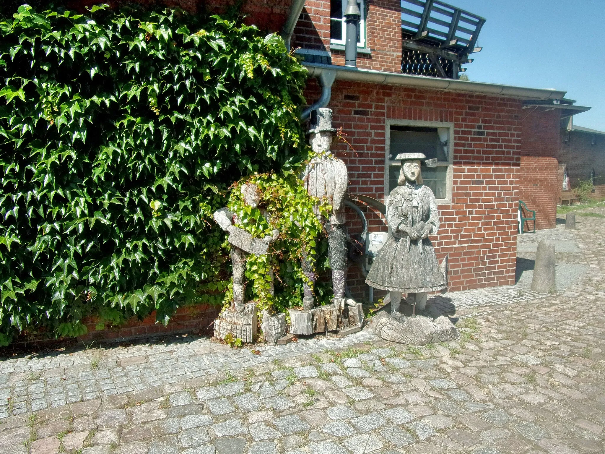 Photo showing: Die Riepenburger Mühle in Hamburg-Kirchwerder ist eine ehemalige Kornwindmühle am Kirchwerder Mühlendamm, im Foto Skulpturen einer Müller-Familie. Die Mühle war bis 1990 zur Futterherstellung in Betrieb, um den Erhalt des denkmalgeschützten Gebäudes kümmert sich der Verein Riepenburger Mühle e.V. Mehr Infos im folgenden Link: http://www.riepenburger-muehle.com/geschichte.htm