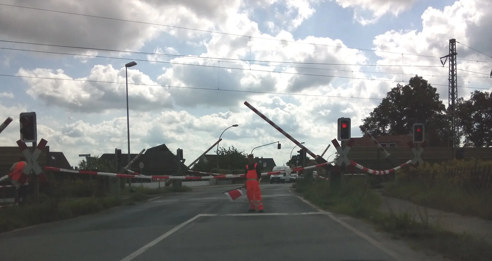 Photo showing: viel befahrener Bahnübergang in Ritterhude (Landkreis Osterholz-Scharmbeck, nahe Bremen), der zeitweise (möglicherweise wg. Wartungsarbeiten am Bü) durch mehrere Schrankenwärter mit Hilfe von Absperrbändern gesichert wurde. Die Schranken schlossen trotzdem, etwa 2-3 Minuten nach der manuellen Absperrung.