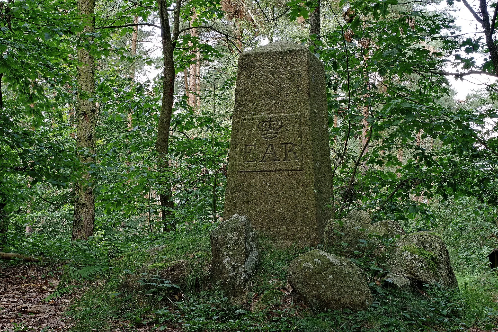 Photo showing: Ernst-August-Rex-Stein auf dem Telegraphenberg im Ortsteil Breetze der Stadt Bleckede - Ansicht aus Südsüdost. Fast mannshoher Granitobelisk, der die Inbesitzname der von den Breetzer Bauern an den königlichen Domänenfiskus verkauften Heideflächen durch Ernst August I. (König von Hannover, Herzog von Braunschweig-Lüneburg von 1837-1851) im Jahre 1847 dokumentiert. Krone und die Initalen verweisen auf den neuen, königlich-herzöglichen Eigentümer: EAR: Ernst August Rex.
Mit dem Verkauf konnten die Bauern die notwendigen Mittel aufbringen, um die auf ihren Höfen seit alters her lastenden Verpflichtungen nach der erfolgten Verkoppelung im Jahre 1838 zu löschen. (Quelle: http://elbstadt-bleckede.de/lexicon/index.php/Entry/301-Ernst-August-Rex/ - abgerufen am 30.09.2017)

Der Stein ist als "Denkst." verzeichnet auf der Online-Karte unter: https://www.umweltkarten-niedersachsen.de/Umweltkarten/ (einzustellende Hintergrundkarte: DGK5 historisch).