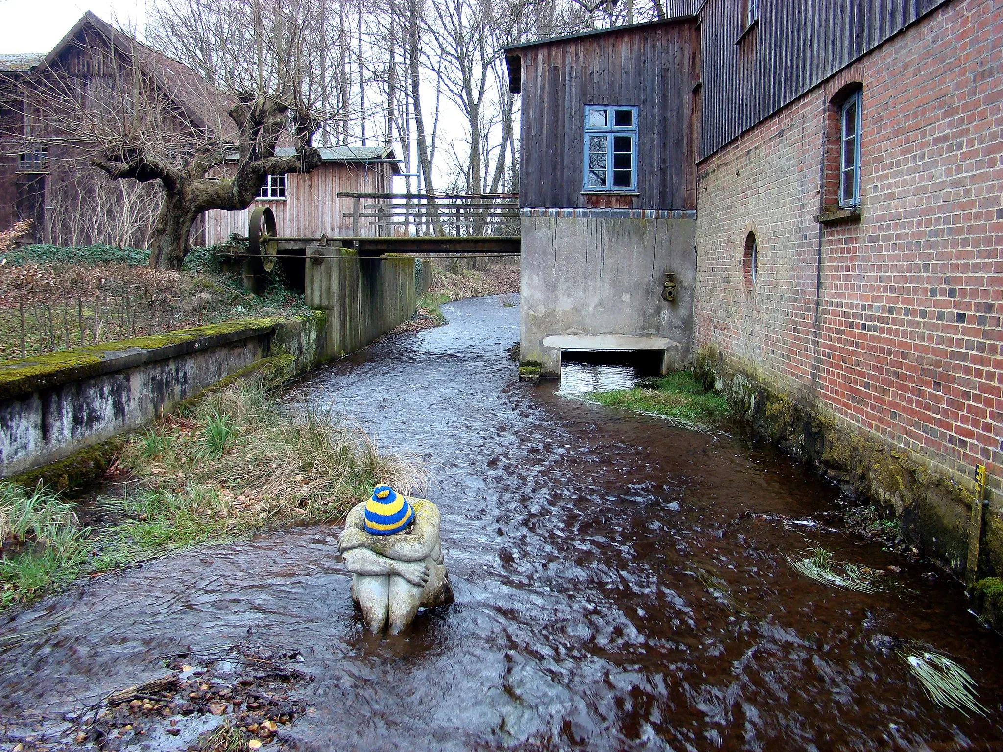 Photo showing: Wassermühle an der Lutter in Marwede mit der Steinskulptur “Die Heide aus Lüneburg” von Petra Förster, einer der „Magischen Punkte in der Südheide“