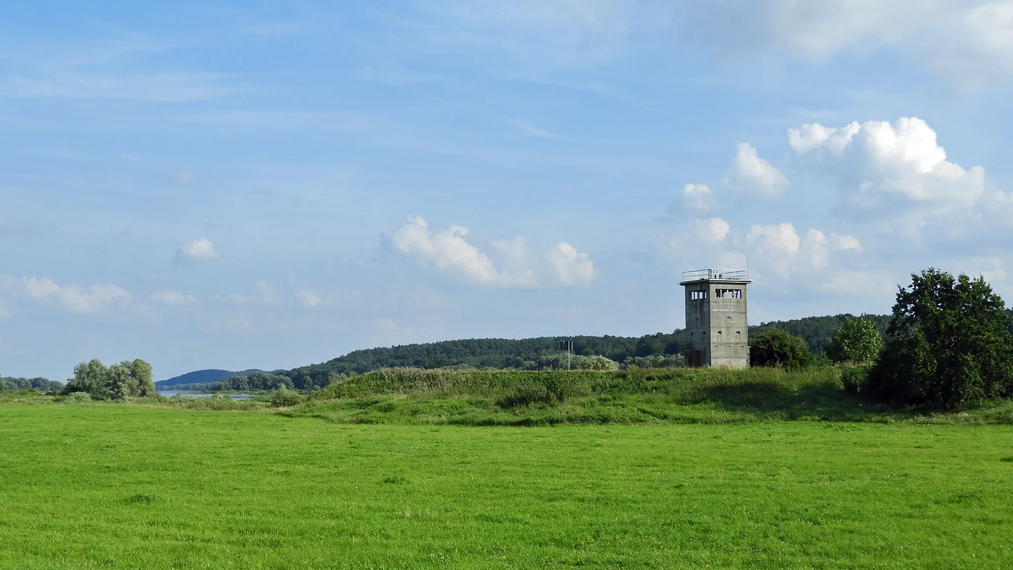 Photo showing: Remnant of a watchtower of the GDR border regime in today's municipality "Amt Neuhaus", southeast of the village Darchau in the dyke foreland of the Elbe river. In the background the wooded, hilly west side of the Elbe (district Lüchow-Dannenberg), in between the Elbe itself. (District Lüneburg, north-eastern Lower Saxony, Germany).