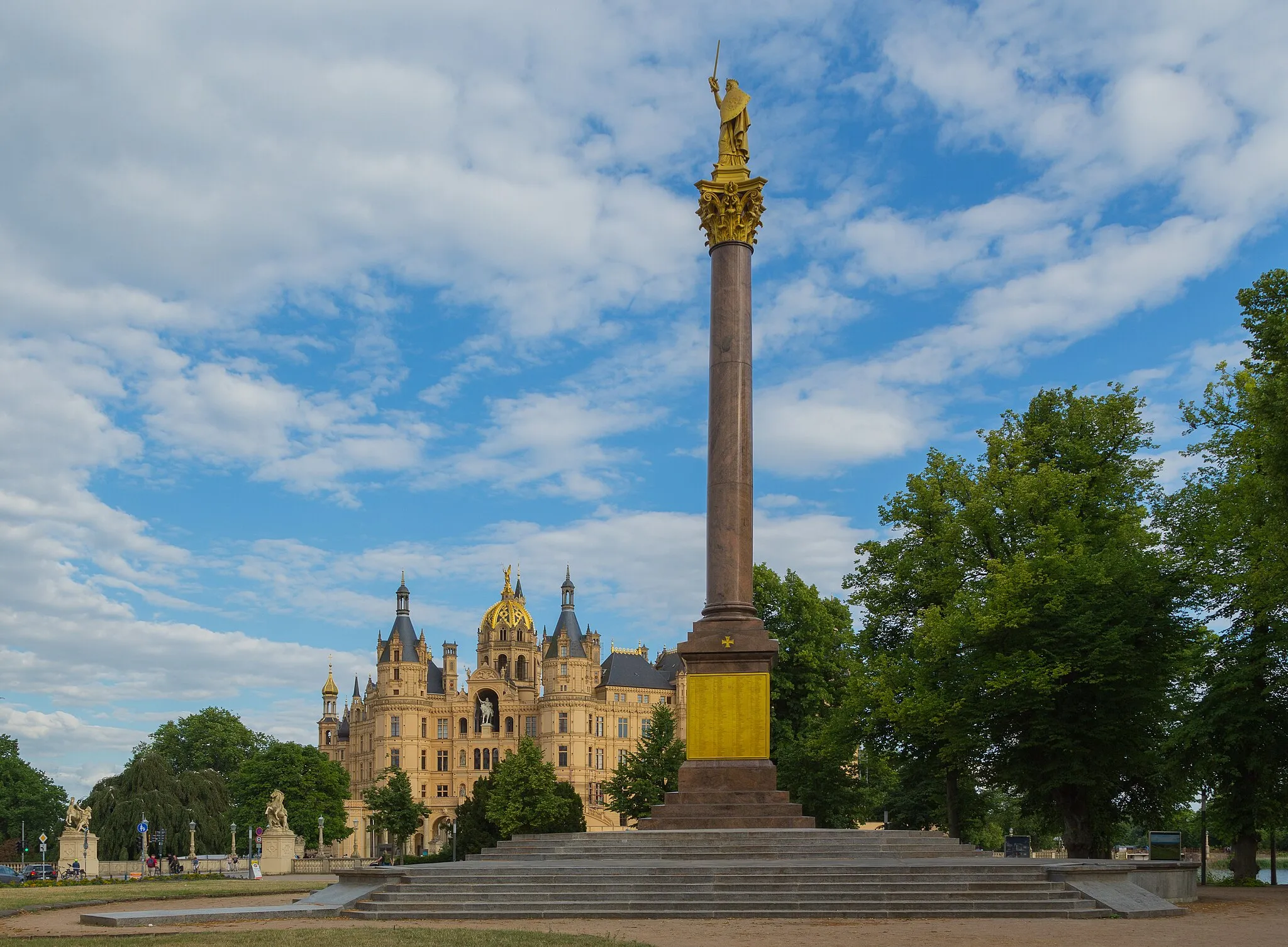 Photo showing: Schwerin Victory Column and Schwerin Castle‎ in Schwerin, Mecklenburg-Vorpommern, Germany. Both are listed cultural heritage monuments.
