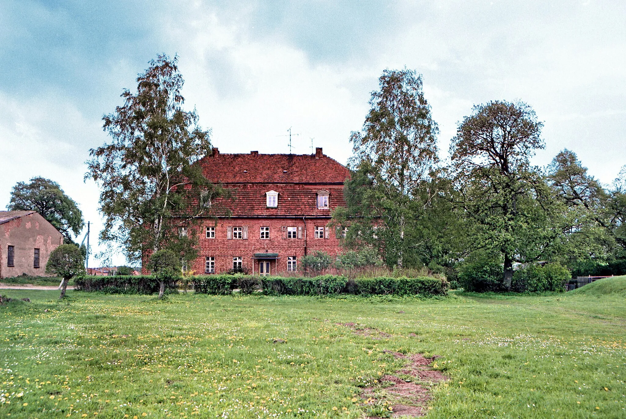 Photo showing: 13.05.1987   DDR 2041  [17153]  Rottmannshagen (Jürgenstorf): Gut Rottmannshagen. 1482 erhielt Hartwig von Moltzahn das Gut und leitete damit eine jahrhundertelange Zeit ein, in der die Familie von Maltzahn den Besitz über den Ort hatte. Von 1728 bis 1732 wurde das barocke Gutshaus im Auftrag von Axel Albrecht von Maltzahn errichtet. 1840 wurde Peter Joseph Lenné mit der Gestaltung des Schloßparkes beauftragt. 1862 übernahm die Familie Wahnschaffe das Gut.  Kurz nach Kriegsende 1945 brannte das Schloß ab. Nach dem Zweiten Weltkrieg wurde das Gut in ein Volkseigenes Gut umgewandelt und diente vor allem der Tierproduktion. Ein großer Schweinemastbetrieb entstand. Im Bild ein erhaltenes Kavalierhaus (GMP: 53.649042,12.859964), Dorfstraße 17.                                                                                                                                                                                                        [R19870513A11.TIF]19870513370NR.JPG(c)Blobelt