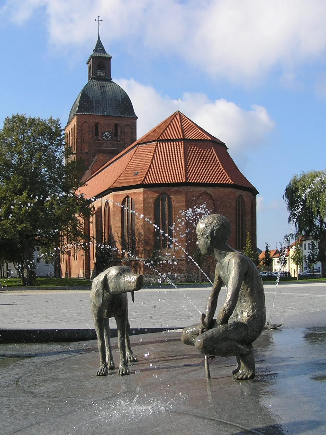 Photo showing: Market place in Ribnitz-Damgarten, Germany: view from the fountain to St Mary's church. The Sculptures were made by Thomas Jastram. The fountain was produced by the Stone-Company Rechtglaub-Wolf from the Hanseatic town of Lübeck.